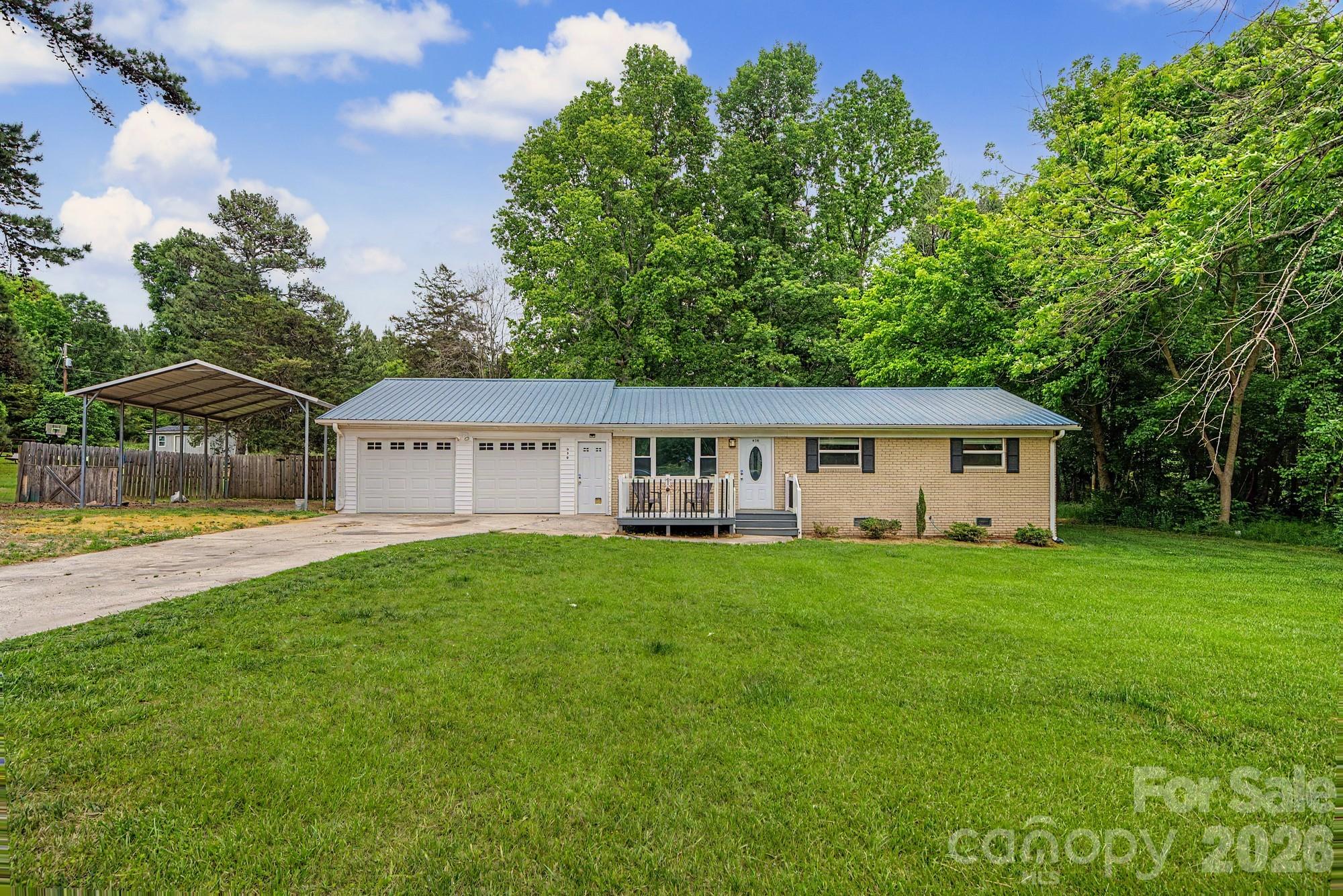 Potential for assumable 2.85% USDA loan for qualified buyers! Darling brick home with a metal roof on .66 acre and no HOA!  Freshly painted and LVP flooring installed on 5/23/26.  3 bedroom, two full bath home with open kitchen and dining area. Front deck overlooking large front yard and very spacious private fenced yard in back.  Two-car garage PLUS a carport with capacity for RV or boat!  Great option for first time home buyer, rental opportunity or someone looking for a solid home with plenty of indoor and outdoor space and privacy.