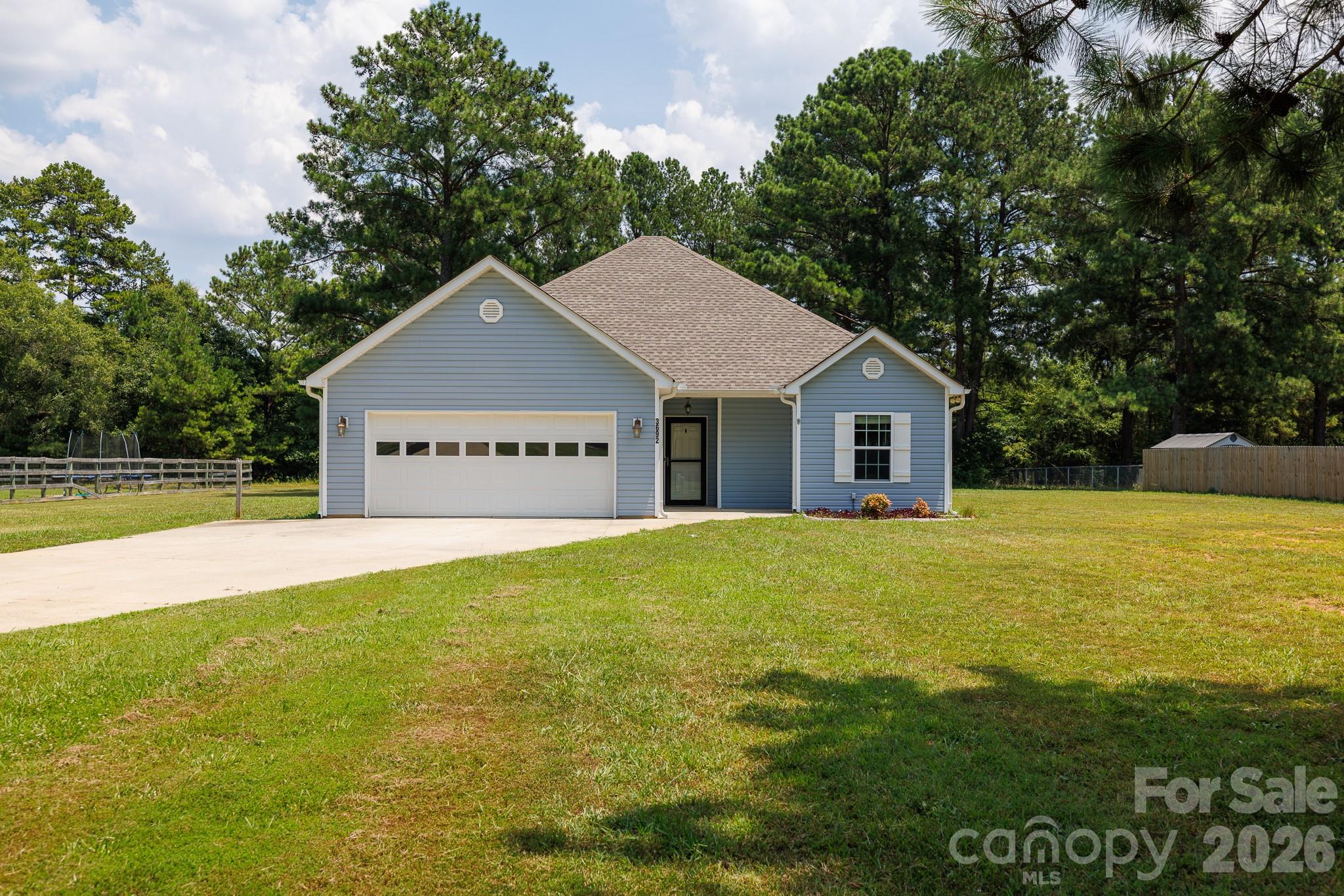 Enjoy the peace and space of country living with all the modern feel of a 2019 build. Situated on a level 1.04-acre lot, this single-story home offers an easy open layout designed for relaxed daily living and effortless entertaining. The kitchen features warm wood cabinetry, granite countertops, a pantry, and stainless steel appliances, seamlessly connecting to the main living space accented by low-maintenance LVP flooring. The thoughtful split-bedroom floorplan offers added privacy for the primary suite, complete with a tray ceiling and a walk-in closet. Step outside to sip your morning coffee on the welcoming front porch, or unwind under the ceiling fan on the covered rear porch while enjoying your expansive backyard. Complete with a two-car attached garage and room to spread out, this property perfectly combines easy comfort with open acreage.