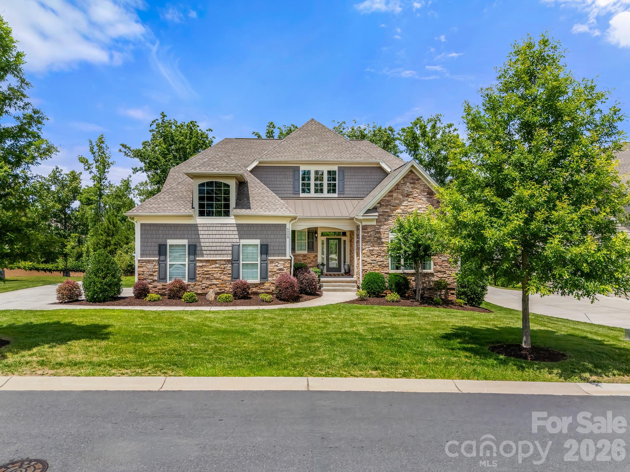 Move right into this meticulously maintained, truly turnkey luxury home in the sought-after Toll Brothers Executive Section of Bent Creek, just 8 minutes from downtown Waxhaw. Perfectly positioned on a premium cul-de-sac lot backing to private wooded views, this tastefully designed home offers the rare combination of elegance, functionality, and low-maintenance living. This home has been thoughtfully updated and meticulously maintained, allowing the next owner to simply move in and begin enjoying everything it has to offer from day one. Designer window treatments, custom finishes, motorized outdoor shades, a finished walk-out basement, professional landscaping, and countless thoughtful improvements have already been completed, creating a home that feels polished, complete, and ready to enjoy. The highly desirable floor plan features both a luxurious primary suite and a secondary bedroom with a full bath on the main level, making it ideal for multi-generational living, long-term guests, or those seeking the convenience of main-level living. A dedicated office with built-ins provides the perfect work-from-home space. The chef's kitchen is filled with natural light and features a large granite island, gas cooktop, generous pantry, and abundant cabinetry, all opening seamlessly to the main living and dining areas for effortless entertaining and everyday living. The primary suite serves as a private retreat with a custom walk-in closet and beautifully appointed bath featuring a spacious walk-in shower with bench seating. Step outside to the covered porch, complete with motorized shade, and enjoy peaceful wooded views year-round. The beautiful landscaping was expertly planned for enjoyment rather than upkeep, providing a low-maintenance outdoor living experience rarely found in homes of this size. Upstairs, a spacious loft, additional bedroom, and full bath provide comfortable space for family and guests. The fully finished walk-out basement offers exceptional flexibility to fit a variety of lifestyles. Currently configured with a dedicated home gym, multiple flex spaces, a full bath, and abundant storage, the layout could easily accommodate a fourth bedroom while still maintaining generous recreational and entertaining areas. Whether you need space for fitness, hobbies, entertaining, a media room, guest quarters, or future bedroom expansion, this level adapts to your needs. Additional highlights include a side-load garage, large laundry room with sink, mudroom with built-in bar area, and extensive storage throughout. Residents enjoy access to Bent Creek's outstanding amenities, including a clubhouse, fitness center, outdoor pool, playground, and scenic walking trails. Beautifully maintained, thoughtfully upgraded, and completely move-in ready, this is a rare opportunity to enjoy luxury living in one of the area's most desirable communities