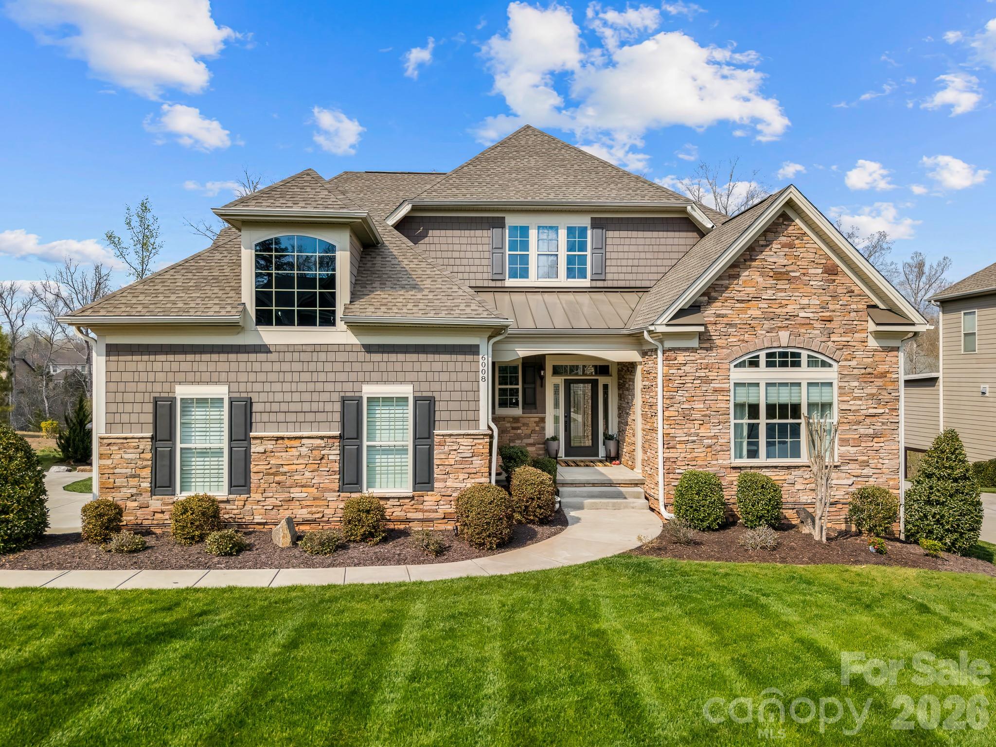 Stunning, meticulously maintained luxury home just 8 minutes from downtown Waxhaw, perfectly positioned on a premium cul-de-sac lot backing to private wooded views in the sought-after Toll Brothers Executive Section of the Bent Creek community. 
This designer-upgraded home offers a refined blend of elegance and functionality, featuring a primary suite on the main level, along with an additional bright bedroom and full bath, a dedicated home office with built-ins, and flexible living spaces throughout. The home feels elegant and welcoming from the moment you enter. The primary retreat includes a custom walk-in closet and a beautifully appointed bath with a spacious walk-in shower and bench.
The chef’s kitchen showcases a large granite island, gas cooktop, generous pantry, and abundant natural light, all opening seamlessly to the main living area, creating an inviting space for both everyday living and entertaining. Designer window treatments and elevated finishes throughout create a cohesive, high-end feel in every room of this lovely home.
Step outside to the covered porch just off the kitchen and dining area, complete with motorized outdoor shades, where you can unwind and take in the peaceful wooded setting year-round.
Upstairs offers a versatile, comfortable loft, an additional bedroom, and a full bath.
The fully finished walk-out basement is a standout feature, offering multiple flex spaces currently styled as a home gym, sauna, and golf simulator, along with a full bath and abundant storage. This level offers incredible versatility to fit a variety of lifestyles.
Outdoor living continues with a beautifully landscaped, low-maintenance yard and direct walk-out access from the basement.
Additional features include a side-load garage, large laundry room with sink, and mudroom with built-in bar area. Enjoy the Bent Creek lifestyle with a clubhouse, fitness center, outdoor pool, playground, dog park, and scenic walking trails.
Move-in ready and set in one of the area’s most desirable locations, this is a home that truly stands apart, offering both everyday comfort and a sense of retreat just minutes from everything.