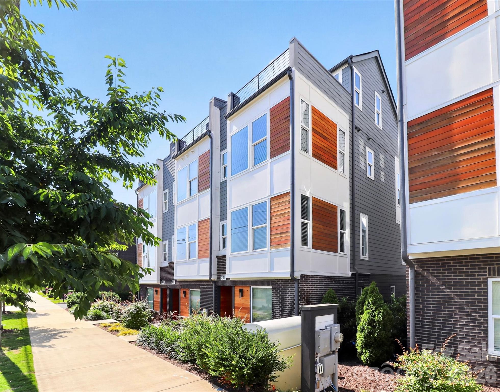 Seller is offering 5,000$ in seller credit at closing. Use it to buy down your rate or towards closing cost. Welcome to Bryant Park Terraces — one of Charlotte's most thoughtfully designed townhome communities, where low-maintenance living meets a location that puts the best of the city within easy reach.
This end-unit townhome offers three bedrooms, two full and two half baths across four floors of bright, well-appointed living. As an end unit, natural light pours through additional windows on every level, giving the home a warm, airy feel that sets it apart. The main living floor is anchored by an open kitchen, dining, and living area that flows effortlessly. The kitchen features stainless steel appliances, a spacious island with white quartz countertops, subway tile backsplash, fresh and vibrant. Step directly from the dining area onto your private balcony overlooking green space and trees. Warmed toned wide plank hardwood floors run throughout, grounding the home's clean contemporary aesthetic. The third-floor hosts bedrooms, including the primary suite with a custom updated closet, and laundry conveniently on the same level. The fourth floor opens to a flexible space with another half bath. Step into the spacious rooftop terrace with open views of the Charlotte skyline, with a private feel that makes it a year-round retreat. The exterior carries the same contemporary clean lines warmed by wood tone accents. Bryant Park Terraces are nestled in the heart of Charlotte's vibrant west side — where the energy of the Queen City is always within reach. Minutes from Uptown, steps from historic Bryant Park, and surrounded by the restaurants, bars, greenways, and culture that make this corner of Charlotte one of its most exciting