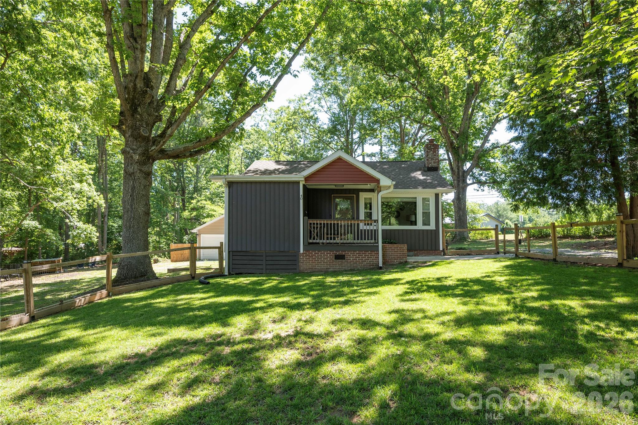 Charming updated bungalow! This magical home was completely renovated in 2022 and then was updated again by its current owners. A few of the homes new features include a completely new kitchen with custom cabinetry, kitchen island, quartz countertops, high end appliances and laminate wood flooring. Home also has a new septic tank, and fencing. The two car detached garage just steps from the back door is great for hobbyists, storage, or even your vehicles! Home is equipped with a Level 2 EV charger and a whole home surge protector. The generous sized .47 acre lot is perfect for gardening, play or your furry friends. This property is in a great location within a few minutes to downtown Hendersonville, shopping, dining, hospitals, interstate travel and the Asheville Airport. Make your plans to view this property soon!