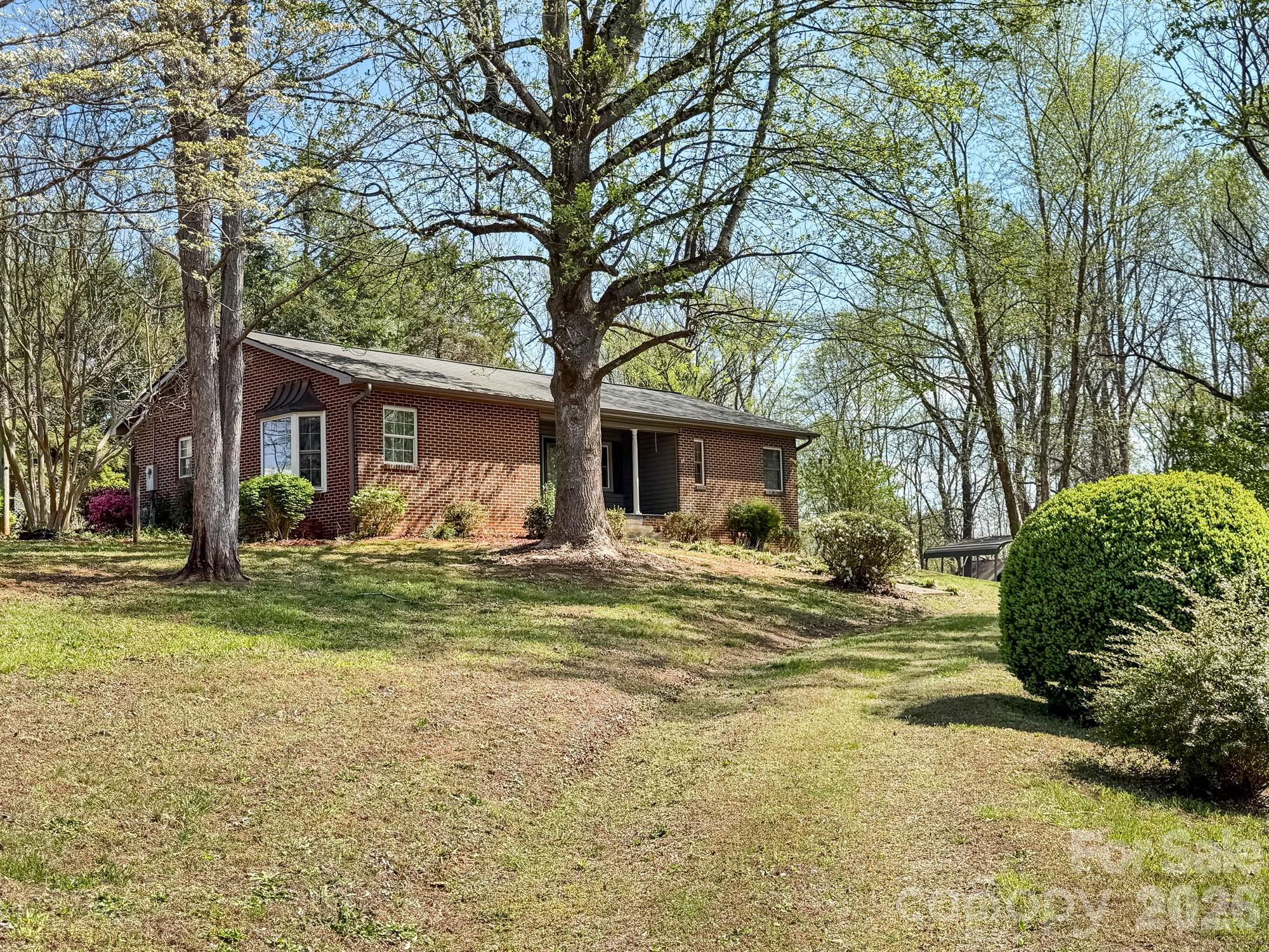 This charming mid-century brick ranch is situated on a very rare spacious corner lot near downtown Morganton! Offering four bedrooms and two full baths, this home provides the perfect blend of comfort, character, and room to grow. Inside, you’ll find generous living spaces designed for everyday living and entertaining alike. The home also features a large laundry area as part of a full bath, adding convenience and functionality to your daily routine.
Downstairs, an unfinished basement offers tons of potential, whether you’re imagining a workshop, future additional living space, or extra storage. Set on nearly 3 acres, this property gives you the freedom to expand, garden, or simply enjoy the extra elbow room that’s getting harder to find in this area. Move in and update as you go, or remove the older aesthetics and use this as a blank canvas and upfit to become your dream home. With its classic brick exterior, corner lot positioning, and abundant space both inside and out, this home is ready for your next chapter!