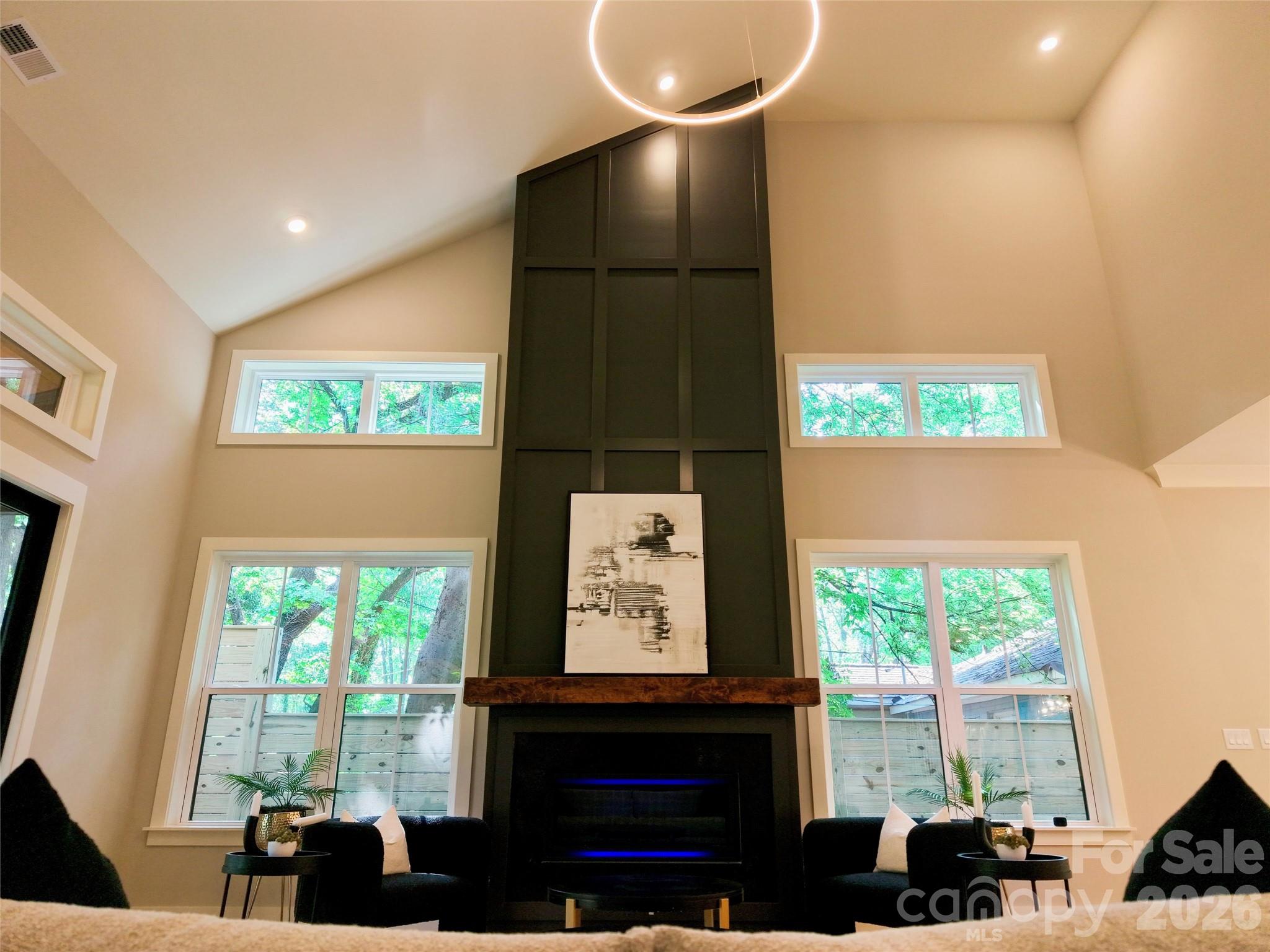 $25,000 SELLER CREDIT towards rate buydown or closing cost with seller-approved financing, allowing qualified buyers to enjoy lower monthly payments.  Across the street from Camp North End, just 1/2 mile to Optimist Hall and only 1.5 miles to Uptown Charlotte. This exceptional new construction home offers, 4 bedrooms, 4 full baths, large loft and private home office, oversized 2-car garage highlighted by a rare main-level primary suite and guest suite, along with a dramatic 20+ foot vaulted great room filled with natural light. Situated on an extra-wide street with a mature tree canopy in Charlotte’s thriving Lockwood neighborhood, the home delivers luxury living in a premier urban location.
The open-concept layout centers around the two-story vaulted great room with a floor-to-ceiling fireplace and oversized windows that create an open, light-filled living experience. The main level features 10-foot ceilings, 8-foot doors, extensive trim details, crown molding, and engineered hardwood flooring throughout.
The kitchen showcases ceiling-height cabinetry with LED glass display cabinets, under-cabinet lighting, Ivoritaj quartz countertops, a waterfall island, custom stained wood hood, and a premium, stainless steel KitchenAid appliance package including a gas cooktop, wall oven, microwave, and refrigerator.
The primary suite includes a spa-style bath with freestanding soaking tub, oversized walk-in shower, and spacious walk-in closet. A private guest suite is also located on the main level. Upstairs offers two additional en-suite bedrooms, a versatile loft, and a dedicated home office with glass French doors.
Outdoor living is elevated with 12-foot sliding glass doors leading to a screened porch with wood-accent ceiling overlooking a large, flat backyard enclosed by a custom 8-foot horizontal privacy fence.
Additional features include custom closets, designer window trim, abundant storage, and a 2-10 Home Warranty. Minutes to NoDa, Plaza Midwood, and Uptown Charlotte. Agent/Owner.