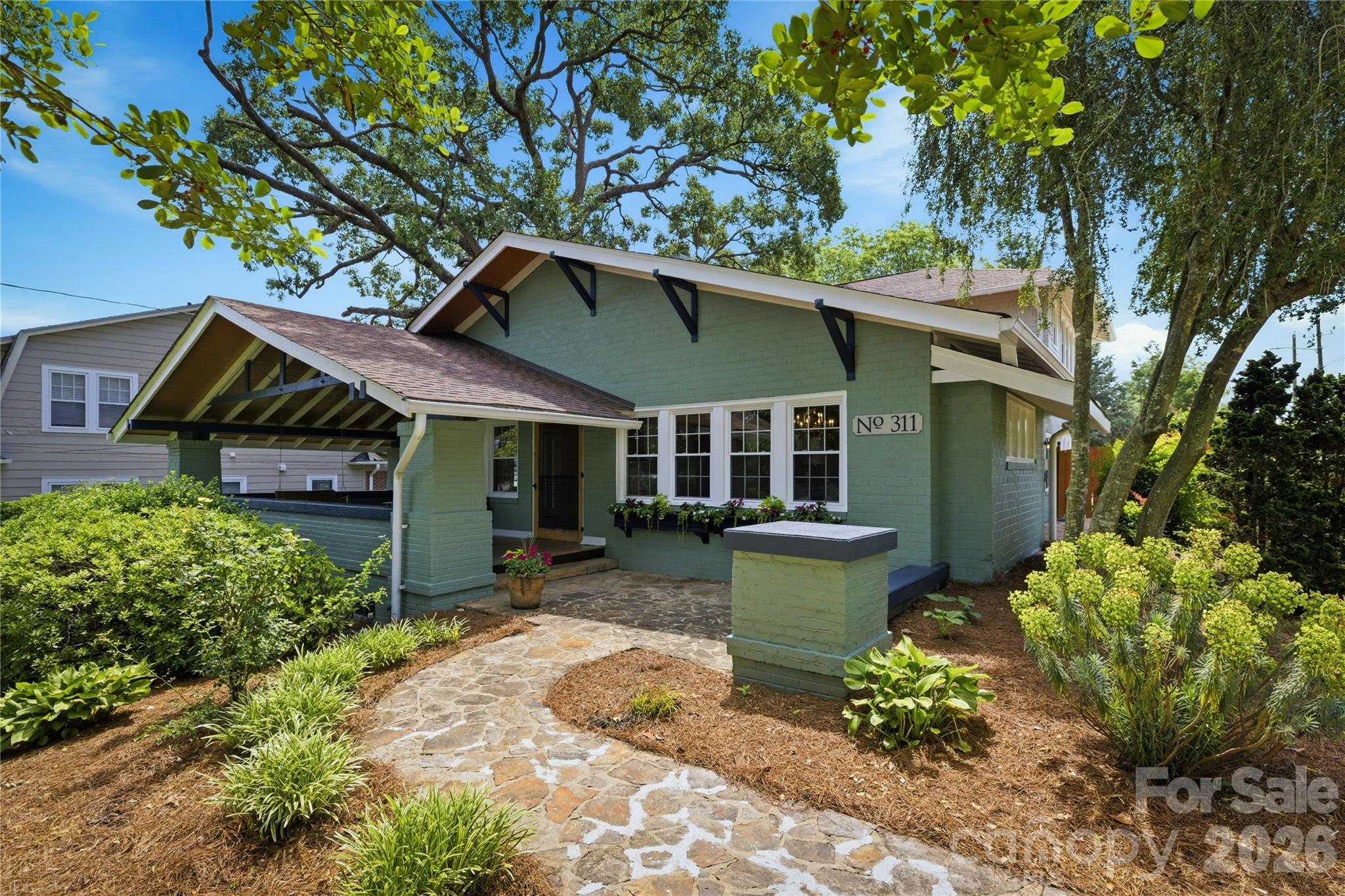 Rare Historic District Opportunity — Iconic 1920s Craftsman Airplane Bungalow

Located just one block from Downtown Morganton, this remarkable custom-renovated home offers a rare blend of architectural significance, rich history, and modern luxury. Influenced by both the Craftsman movement and Prairie School design, the home was built by R.O. Huffman, son of the founder of Drexel Furniture.

A stunning 547-square-foot front porch welcomes you home, featuring restored original hardwood flooring and the home's original Dutch entry door with a matching screen. Inside, the inviting living room showcases a fireplace with gas logs, a dramatic custom-vaulted ceiling with exposed beams, and beautifully refinished hardwood floors that continue throughout the home, preserving its timeless character while enhancing everyday comfort.

The extensively renovated kitchen blends style and function with KitchenAid appliances, including a commercial-style gas range, custom cabinetry, quartzite countertops, a center island, pantry, designer lighting, and an open-concept layout ideal for entertaining. A spacious dining room connects the kitchen and great room, creating a natural flow for gatherings and daily living.

The main level features a private primary suite with an updated bath and direct access to the fenced saltwater pool area, creating a peaceful retreat. Two additional bedrooms—perfect for guests, home offices, or flexible living spaces—share a hall bath complete with a jacuzzi tub. A bonus room in the partially above-grade basement offers endless possibilities as a fitness room, playroom, media room, or additional bedroom.

Upstairs, you'll find two generously sized bedrooms connected by a Jack-and-Jill bath featuring original tile floors and walls, vintage fixtures, and a beautifully refinished tub/shower. This level also includes oversized walk-in closets, custom built-ins, a cedar closet, and a walk-in attic providing exceptional storage. A new HVAC system was installed (2026) to serve the upper level.

Historic details abound throughout the home, including original functioning door hardware with skeleton keys, vintage switch plate, brass thresholds, and brick handcrafted on-site during the home's construction. A full basement and detached garage—originally connected to the home by a columned pergola—offer additional possibilities, including potential use as an ADU, guest quarters, studio, or Airbnb. Behind the garage, a private garden sanctuary provides a peaceful outdoor escape, while an added parking area enhances convenience.

Rich in history and architectural authenticity, yet thoughtfully updated for modern living, this exceptional property occupies one of Morganton's most desirable locations. Enjoy being just steps from downtown dining, shopping, breweries, and entertainment while remaining only minutes from Lake James, Pisgah National Forest, and the endless hiking, biking, and outdoor recreation opportunities of Western North Carolina.

A truly rare opportunity to own one of Morganton's most distinctive historic homes.  Broker/owner