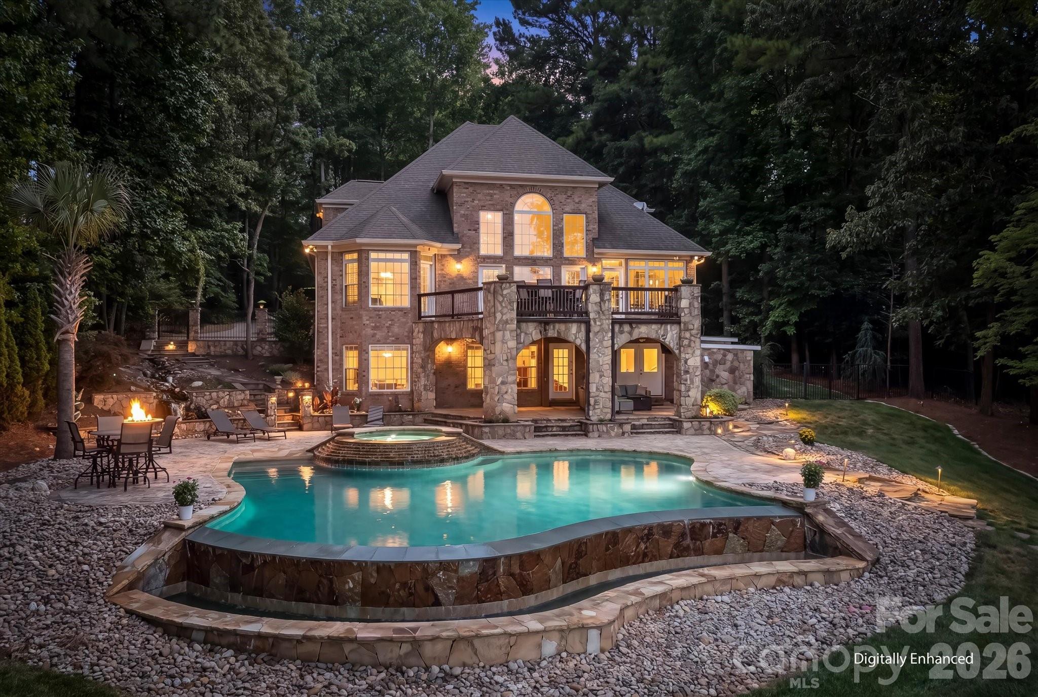 Welcome to your ultimate luxury retreat! This custom brick & stone waterfront home sits on 2.06 secluded acres and boasts over 550 feet of stunning Lake Norman shoreline. What makes this property truly exceptional is the VIEW. Perfectly positioned to overlook 1,300 undisturbed acres of Lake Norman State Park, what you see now is what you will always see - surrounding, unchanging nature. It is an absolute dream for outdoor enthusiasts, offering direct access to the park's hiking and biking trails or kayaking and paddle boarding off your private dock. Step inside to discover gorgeous hardwoods flowing through the main level leading you into a breathtaking two-story great room with a gas log fireplace framed by a spectacular wall of windows to maximize your views. The gourmet kitchen is a true chef’s masterpiece featuring exquisite heated travertine flooring, premium 42-inch cabinets and beautiful granite countertops. High-end appliances include a six burner Thermador range & oven complete with a pot filler, a wall oven and built-in convection microwave, as well as an integrated trash compactor. The expansive center island doubles as a perfect prep space, complete with a vegetable sink & beverage cooler. The breakfast area and sitting room flow onto the outdoor stone deck, featuring a built-in grill and granite eating bar with built-in fire table. Retire to the main-level primary suite with radiant heated floors, a private haven with direct deck access to take in the serene lake views. The spa-like ensuite boasts dual vanities, a tiled step-in shower and a relaxing soaking tub. “His and hers" closets are incredibly convenient with direct access to the laundry room. Upstairs, family & guests will enjoy spacious bedrooms perfectly configured with an ensuite and 2 additional bedrooms with a Jack-and-Jill bathroom. The lower level is built for entertaining! Featuring beautiful heated travertine floors, this space boasts a billiards room complete with a bar, beverage cooler, kegerator and an elegant wine niche. As well, the flex space/office or exercise room features another full bath. Host movie nights in the state-of-the-art home theatre, complete with AV equipment and six automatic reclining chairs that convey with the home! An additional versatile flex/workshop space with double doors complete the lower level. Step outside into your own private resort. The covered patio leads down to a stunning infinity-edge pool, a custom overflowing hot tub and a tranquil Koi pond with a cascading waterfall. The lakeside firepit is perfect for evening fireside chats after a day out on the lake. As well, for the handyman or car enthusiast, don’t miss the 2-Car Detached Garage with additional conditioned space above. This space also features a built-in “doggie-bath” station and ½ bath. Don’t miss the rare opportunity to own this spectacular, secluded Troutman estate with unparalleled views overlooking beautiful Lake Norman!