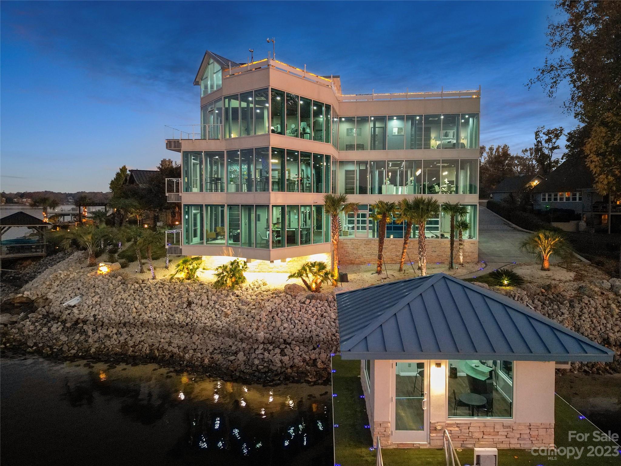 Embark on an enchanting journey with both sunrise and sunset in this exceptional 6-bedroom, 6.5-bath residence spanning over 6,500 square feet. Immerse yourself in unparalleled views of Lake Norman through expansive walls of glass. The main level is a haven for in-laws or guests, featuring a complete Thermador kitchen, 2 bedrooms, a laundry area, and a welcoming living space. Elevate your experience by taking the elevator to the second level—a true spectacle awaits!

For those who relish hosting, the second level showcases an awe-inspiring bar, making a bold statement in entertainment. Challenge yourself to discover a more remarkable spot to gather friends and family while setting the stage for unforgettable gatherings. Completing the second level is a full dining area, gourmet kitchen, and an additional bedroom. As you ascend to the third floor, the main suite and two additional bedrooms reveal even more stunning vistas, culminating in a rooftop deck with a 250-foot covered hot tub.