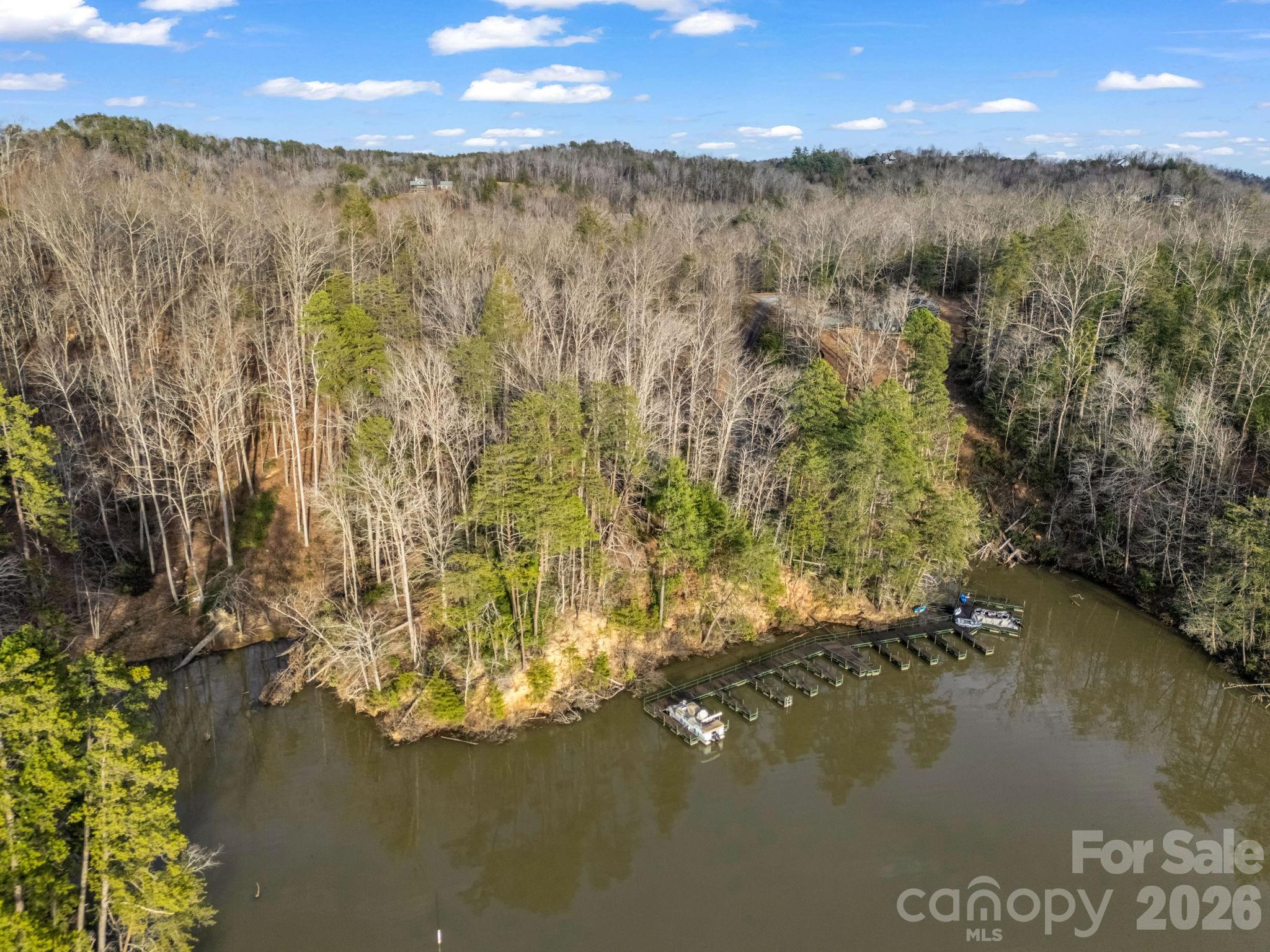 This parcel is a true gem!  If you are interested in waterfront property on Lake Adger with gently sloped topography and year round mountain views that includes a deeded boat slip then your search is over!  There are so many wonderful things about this lot that make it extra special!  As you walk in you are automatically drawn toward the water.  It seems like a serene private park where wildlife abounds.  I was greeted by 5 deer and 3 large turkeys that left me to peacefully enjoy the natural beauty, listen to the birds and gaze at the lake and surrounding mountains.  There is a flagged cart path that connects the parcel directly to the Jackson Cove Marina and the deeded boat slip.  Please use caution as there are several downed trees along the path.  Lake Adger is a 438 acre lake encompassed by 14 miles of shoreline.  Residents may enjoy the miles of equestrian or walking trails in this planned development.  Please don't miss this opportunity to own one of the most beautiful lakefront lots in this picturesque community!
