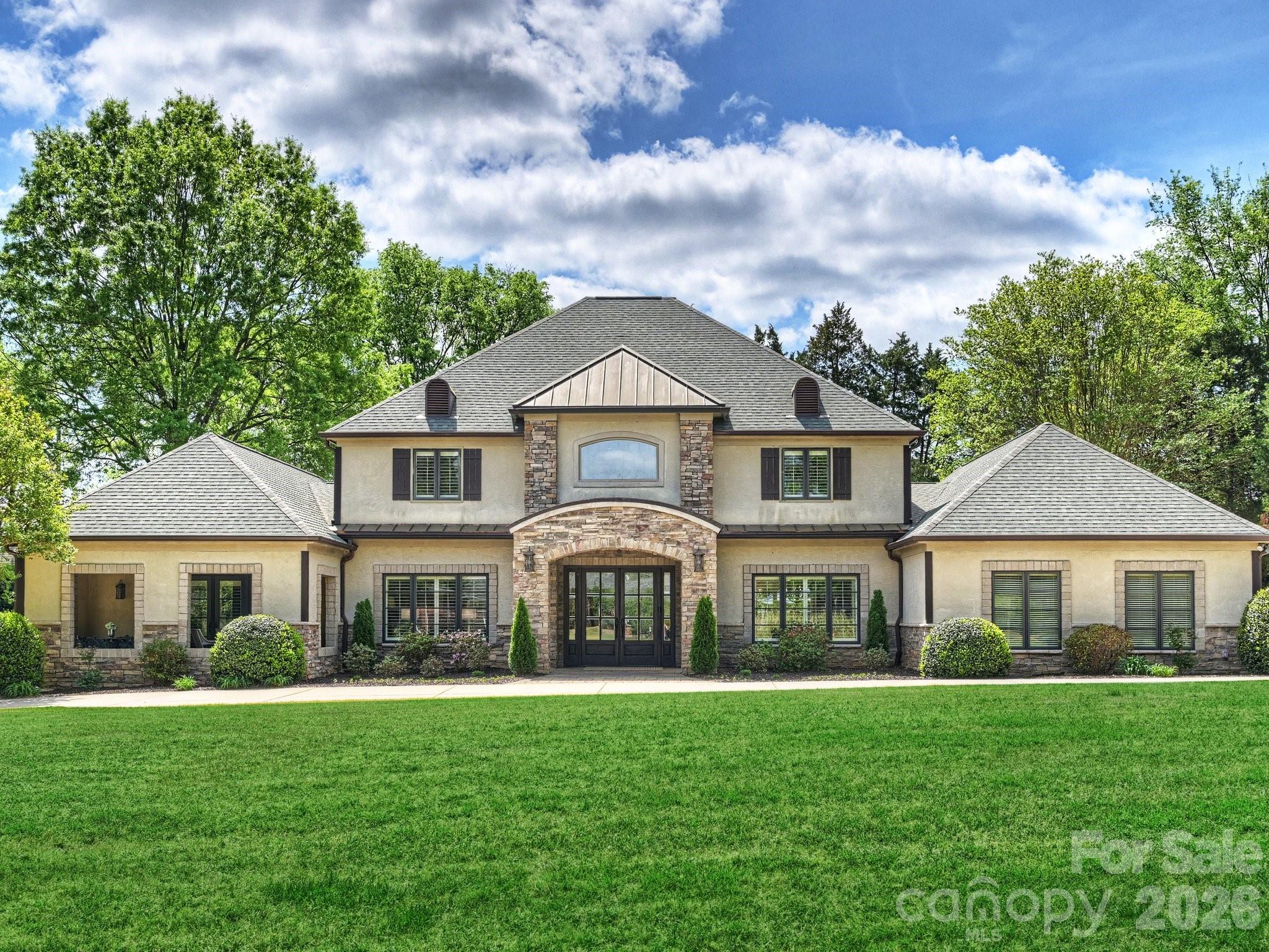 Welcome to this stunning and elegant estate, perfectly situated on .7 acres along the 2nd hole of Carmel Country Club’s north course, just steps from the clubhouse. This beautiful 6-bedroom home with 5 full and 2 half baths offers a warm, inviting, and practical layout. Step into the two-story foyer with its graceful, curved staircase, leading to a spectacular great room featuring reclaimed beams, an oversized limestone fireplace, and beautiful, expansive windows with backyard views. The large, updated chef’s kitchen boasts custom cabinetry, professional-grade appliances, and a spacious island, flowing into a charming breakfast room with a built-in window seat, custom shelving, and pool views. The dining room showcases built-in glass-front cabinetry for display. The den/media/office/playroom is a cozy retreat with its own gas fireplace. The kitchen, dining room, great room, living room, and multi-purpose room connect with high ceilings and an open floor plan. The main level primary suite is very spacious, occupying its own private wing, with a beamed cathedral ceiling, two custom closets, an updated bath, and patio doors to a 235 sq. ft. loggia for morning coffee or afternoon relaxation. There is plenty of room to have a sitting area within the primary bedroom. A guest suite with a private bath sits on the opposite main-floor wing, great for in-laws, guests, or a nanny. Upstairs, four generously sized bedrooms are featured, each with its own bath. Practical areas are a main-level laundry room with an unusually large amount of storage, a custom drop zone with many built-in cabinets and desk, two attic spaces, and an extra-deep and wide two-car garage. High ceilings, heavy moldings, arched casings, solid doors, plantation shutters, and fresh updates add charm throughout. Outdoor living shines with a heated saltwater pool and spa and a 385 sq. ft. pool cabana house with gas fireplace and vaulted ceilings. If a member of Carmel Country Club, the back gate is a quick and easy access to the clubhouse. Not a member, the yard is private, quiet, and enjoyable and the back yard is great for entertaining family and friends!