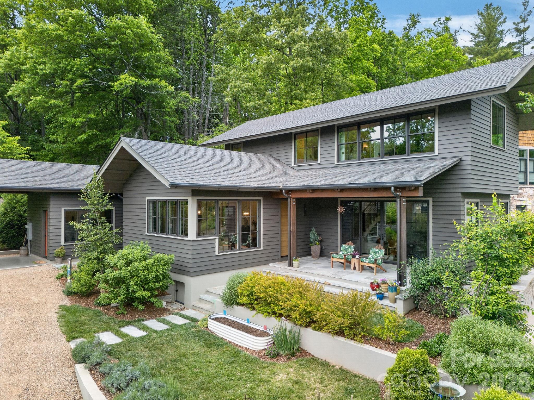Designed by acclaimed architect Scott Huebner, this exceptional residence blends timeless architecture with modern simplicity in the highly sought-after Village of Cheshire community. Thoughtfully designed with clean lines, warm finishes, and an extraordinary window package, the home is filled with abundant natural light and a calming connection to the outdoors.

The flowing floorplan offers three private bedroom suites, custom cabinetry throughout, and a beautifully appointed kitchen featuring Bosch appliances. Every detail reflects understated quality and intentional design, creating a home that feels both refined and comfortable.

Outdoor living is equally inviting with a peaceful rear patio, manicured landscaping, and a charming herb garden that enhances the home’s relaxed mountain atmosphere.

Located within the health-oriented and classically inspired Village of Cheshire, residents enjoy a unique walkable community designed to foster connection and lifestyle. The masterplan was created by internationally renowned urban planners, integrating homes within walking distance of the parks, trails, pickleball courts, the YMCA and the Village of Cheshire shops and restaurants. This is a rare opportunity to own a thoughtfully crafted architectural home in one of the Asheville area’s most distinctive communities.
