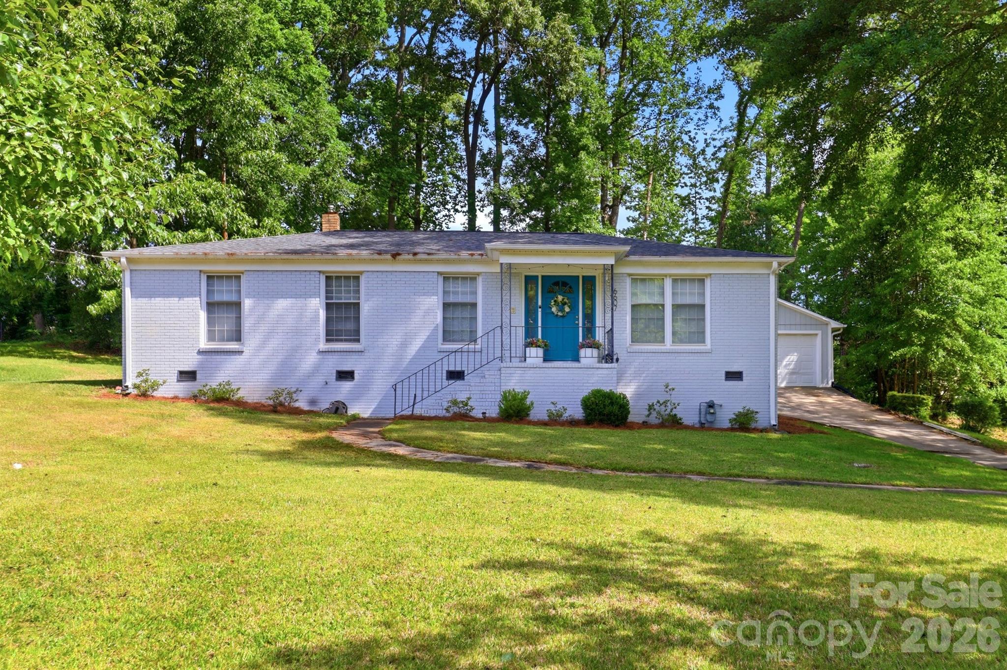 Charming full-brick ranch in Charlotte's Coulwood area with no HOA and one-level living at its finest! This move-in ready 3BR/2BA home features gleaming hardwood floors, recessed lighting and custom wainscoting. The fully renovated kitchen impresses with white shaker cabinets, granite countertops, and stainless steel appliances. A designer accent wall and open flow to the dining room add modern character throughout. Primary suite includes a walk-in closet. Step outside to a covered patio with metal roof, wood beams, and café lights — perfect for year-round entertaining. Fenced yard, mature trees, and a detached garage offer rare versatility at this price point. Less than 15 minutes to Uptown Charlotte with easy access to I-85, I-485, and CLT Airport.