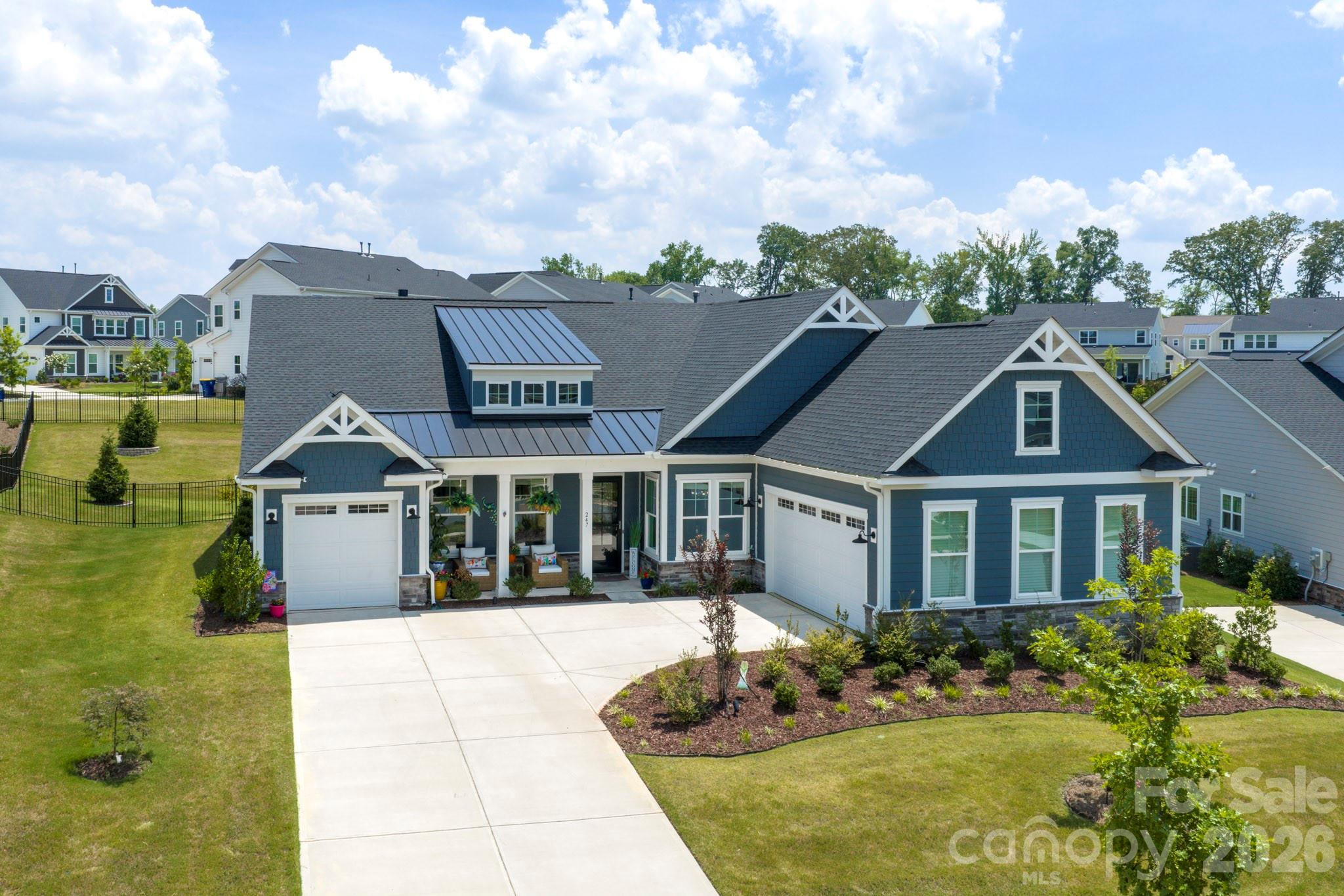 McLean South Shore stands as one of Lake Wylie's most coveted waterfront communities, and this meticulously maintained 2023 Tri Pointe home delivers the kind of refined, turnkey living that buyers search years to find.
From the moment you arrive, the curb appeal commands attention with brick and stone exterior, 30-year architectural roof shingles, Royal James Hardi Color Plus siding, and a fully sodded Bermuda grass yard with a complete landscape package. Step through the front door and a stunning crystal chandelier sets the tone in the grand foyer, where soaring 10-foot ceilings and 8-foot doors create an immediate sense of arrival and elegance.
The open layout features a  gourmet kitchen overlooking the living room, ideal for entertaining and everyday living alike. Quartz countertops, tile backsplash, and a generous island anchor the space beautifully, while the partial overlay slow-close cabinetry with soft-close doors and drawers and a full convenience package providing roll-out drawers in every lower cabinet delivers the kind of thoughtful craftsmanship that sets this kitchen apart. Premium appliances elevate every meal, including a WiFi-enabled GE Profile Advantium Series Double Oven with built-in camera, a GE Profile 5-burner gas stove, and a WiFi-enabled GE dishwasher. The great room centers around a 36" gas fireplace with granite surround, and with the open floor plan, the entire main level flows perfectly.
The oversized primary suite is a true retreat, impressing with a spa-like bath featuring a standalone soaking tub, frameless shower, his and her vanity, and Blanco Matrix quartz countertops, all finished with Delta Chrome fixtures. The spacious walk-in closet offers solid shelving and rod, designed for both function and organization. Secondary baths are equally polished with the guest bath features elegant frameless Kohler shower doors, Sterling elongated toilets, and Delta Chrome fixtures throughout.
Practical living is elevated here as well with a spacious mud room/drop zone keeps daily life organized, while the large laundry room adds the kind of everyday convenience that makes a house truly livable.
Step outside and discover an outdoor living experience that rivals any resort. A charming palm tree anchors the backyard landscape, setting a relaxed, vacation-inspired tone. The backyard features an expansive custom paver patio with a gas fire pit gathering space, perfect for entertaining. The covered rear patio is finished with epoxy-sealed flooring for lasting protection against water seepage, and the entire backyard is enclosed within a private fenced yard, anchored by 12 Green Giant arborvitae that create a lush, natural privacy screen you'll enjoy year-round.
The 3-car garage is fully finished with drywall, paint, an 8' insulated Wayne Dalton door, and a 220V EV charging outlet, ready for modern living from day one.
For the tech-forward buyer, the home's HomeSmart® package delivers everything you'd expect from a truly intelligent home: Eero Mesh WiFi, Leviton smart switches, Ring Pro Doorbell, Genie WiFi garage door opener, Honeywell T6 smart thermostat, WiFi keypad deadbolt, whole-home surge protection, and RG6/CAT6 high-speed wiring throughout, including hardwired TV connections to the main router.
Energy efficiency is built in, not bolted on: Rinnai gas tankless water heater, 15 SEER gas HVAC, MERV 13 air filters, Energy Star® appliances, and water-efficient fixtures throughout.
Enjoy resort-level community amenities just steps away — two marinas, an Olympic-size pool, full fitness center, clubhouse, event lawn, library, dog park, playground, picnic areas, and walking and biking trails connecting directly to The Stowe Conservatory. Lake Wylie access includes a community boat lift, boat ramp, dock, and paddlesport launch.
Owner-occupied since new with no pets and zero wear-and-tear as this home shows like a new Model. Easy to Show