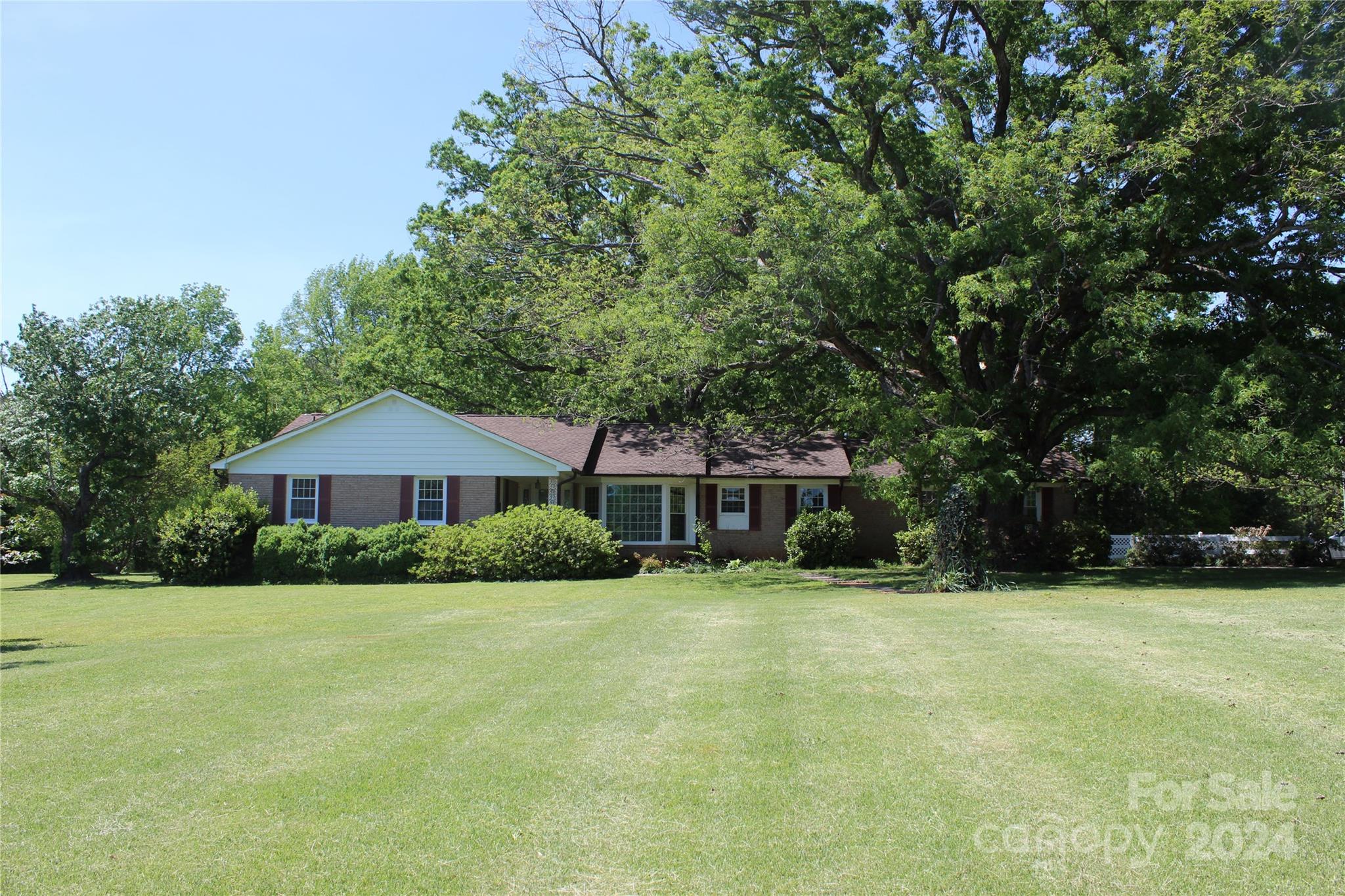 Don't miss this opportunity! Spacious 3BR/2BA brick ranch situated on 3.37 acres with huge oaks and mature trees. White split rail fencing across the frontage of the property.  Includes a 30x50 detached garage/shop with 2 garage doors. There are two smaller storage buildings on the property. Home features large living room with lots of natural light. French doors lead you to the den which features a fireplace and built ins with access to the patio, and a pocket door to close off the kitchen area if needed. The kitchen has a breakfast nook and there is a separate dining room with large bay window and great natural light.  The primary bedroom has 2 closets and a primary bathroom. Freshly painted interior. Some hardwood floors. New LVT tile in den and kitchen/breakfast nook.  Retro Ceramic in bathrooms.

All of this conveniently located minutes from I-77 and/or Dave Lyles Blvd for retail and restaurants. The feel of country living but close proximity to the city!