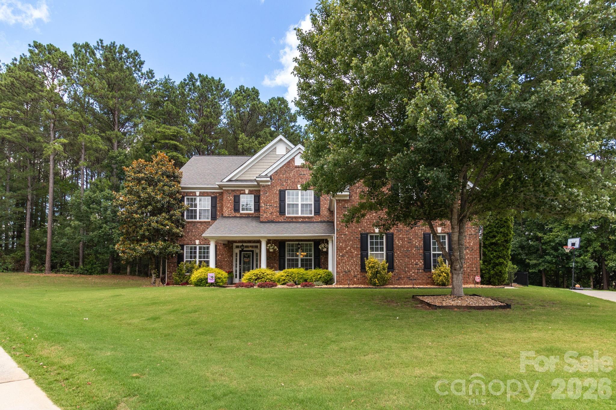 Situated on one of the largest homesites in Wesley Oaks, this beautifully maintained 6-bedroom home combines a spacious and flexible floor plan with a private backyard retreat featuring a pool, stone patio, fire pit, and wooded views. Nestled on an impressive 0.80-acre cul-de-sac lot, this exceptional property offers the perfect balance of privacy, functionality, and outdoor living while remaining conveniently located near shopping, dining, everyday conveniences, and highly sought-after Wesley Chapel / Weddington Union County schools. The thoughtfully designed floor plan features six bedrooms, each with custom closet systems, including a generously sized sixth bedroom that offers incredible flexibility to meet your needs. Whether used as a bonus room, media room, playroom, home office, fitness space, or guest suite, this versatile area easily adapts to your lifestyle. At the heart of the home, the beautifully appointed kitchen showcases granite countertops, stainless steel appliances, custom pantry shelving, and an open layout overlooking the great room, creating an ideal space for entertaining and everyday living. Additional upgrades include waterproof luxury vinyl plank flooring, recessed lighting, surround sound, a tankless water heater, and Trane HVAC system. Step outside and enjoy your own private outdoor oasis. The expansive backyard was designed for entertaining and relaxation, featuring a sparkling pool, hot tub, large stone patio, built-in fire pit with seating, surround sound speakers and a wooded backdrop that provides exceptional privacy and a peaceful setting year-round. With its rare combination of six bedrooms, flexible living spaces, extensive upgrades, resort-style outdoor amenities including pool and playground just moments away, and a location within one of Waxhaw's most desirable communities, this move-in-ready home offers an exceptional opportunity!