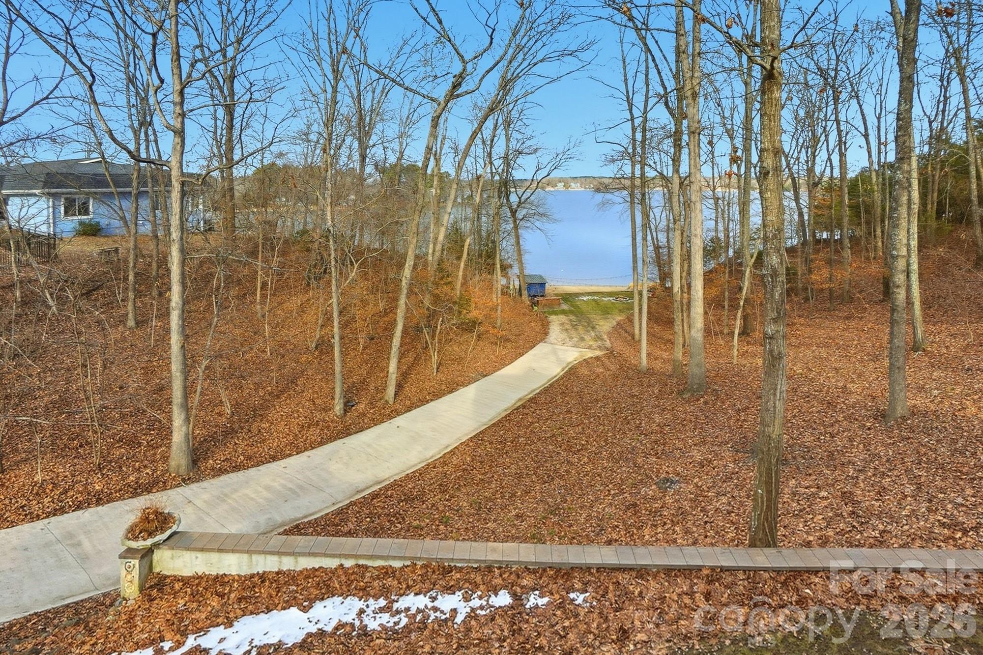 DOCKABLE custom waterfront home on the main channel of Lake Wylie! Enjoy the pristine shoreline with a rare natural sandy beach and firepit, perfect for lakeside entertaining. This property is beautifully landscaped with stone walkways, outdoor cooking station, and multiple picnic areas, all designed to maximize outdoor living. Inside, the home features a primary suite on the main level, formal dining room, and a two-story great room with a stone fireplace. Large windows frame the space while a glass door opens onto a covered porch stretching the length of the home, complete with half-glass panels for unobstructed panoramic lake views. The large unfinished basement offers endless potential, including a garage, recreation area, and abundant storage. Mature trees provide exceptional privacy, and multiple outbuildings offer ideal storage for gardening equipment, lake toys, or hobbies. Whether launching a kayak, gathering around a firepit by the shore, or simply taking in the view from your porch, life on the water invites you to slow down, entertain effortlessly, and enjoy every season! With limited availability and timeless demand, owning on the water isn’t just a lifestyle choice—it’s a smart investment in how you live!