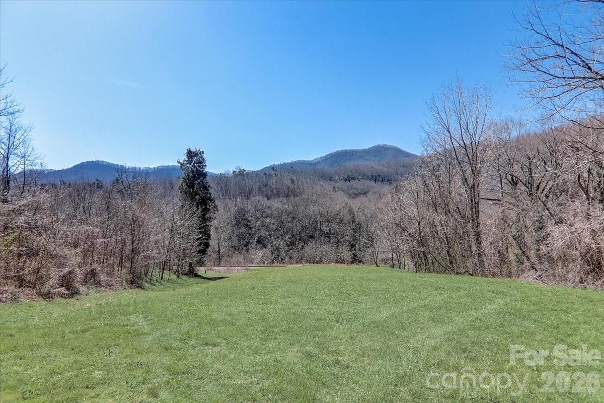 Great 12.47 acres of Open Use land at the west end of Buncombe County approximately 20 minutes from downtown Asheville. Former location of the Historic Turnpike Hotel which was built in the 1860's and had two hotel buildings and a store across the railroad tracks. Located on the Turnpike between Asheville and Murphy. Rolling pasture with a large number of potential uses to include: warehousing/light industrial, multi-family, tiny home community, manufactured home park, large residential estate, residential subdivision, and any other creative event space or wedding venue. Gorgeous stream (Hominy Creek) bisects the property and a railway line which could potentially be utilized (buyer to confirm). Road frontage along Smokey Park highway gives plenty of access for any number of development concepts. Also known as 59 99999 Ridgeway Rd.