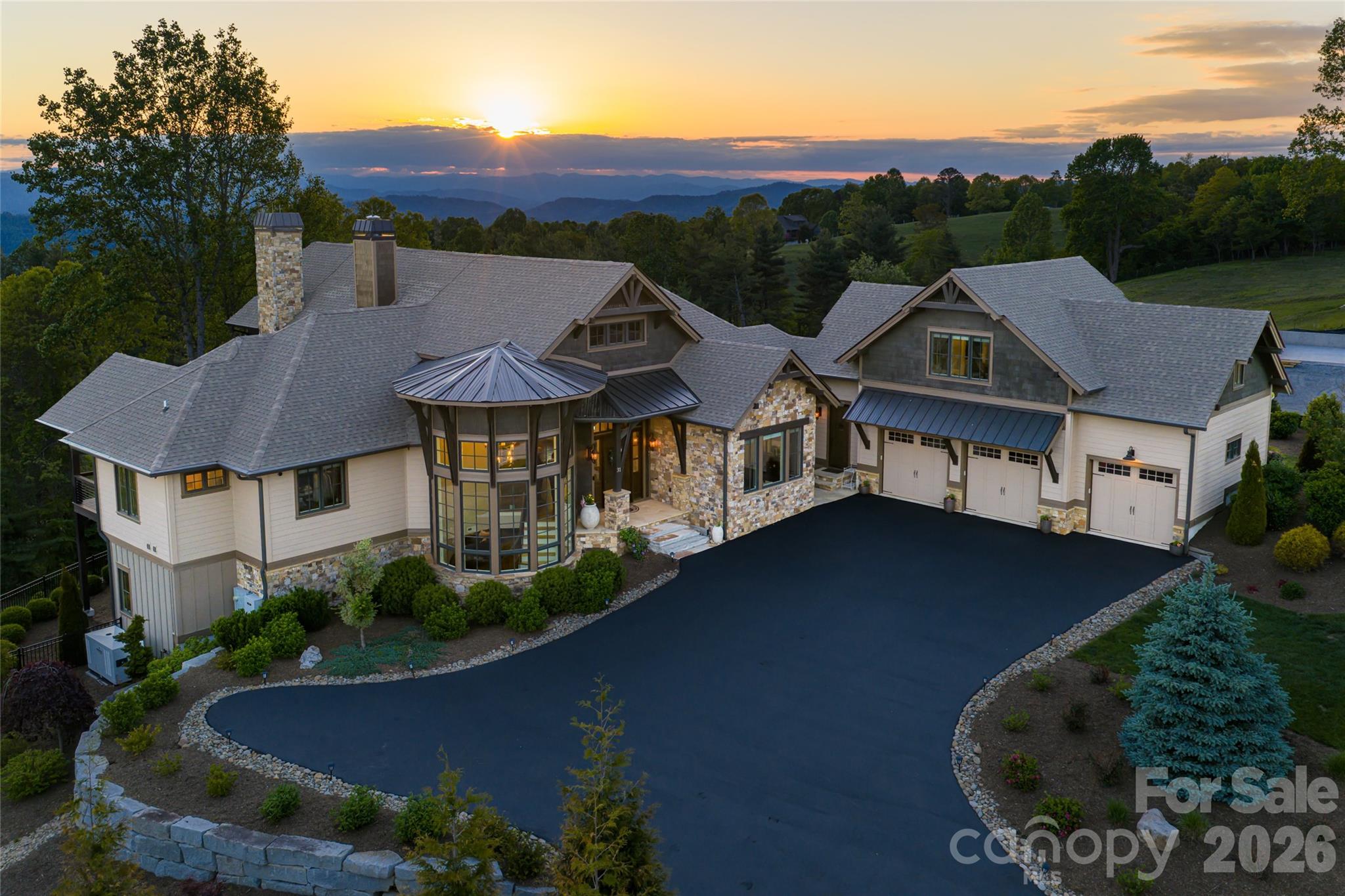 Impressive by design, inspiring by nature, this is a home built for living well. 6,622 square feet of mountain architecture as beautiful to inhabit as it is to behold. 

Step inside and this exceptional home opens immediately before you. To the left, the cylindrical turret draws the eye upward, its windows wrapping nearly the full width from base to top, drawing light around a helical staircase and chandelier in an architectural moment that sets the tone. Ahead, the great room stretches toward large windows and glass doors with the mountain view beyond, cathedral ceilings, exposed timber trusses, a stone fireplace, and light pouring in from every direction. The main level floorplan flows openly, carrying you from the great room into the kitchen, where quartzite counters, a professional Thermador range, Sub-Zero refrigerator, and an 11' island designed for real cooking and entertaining, meet a separate bar with wine refrigerator for the effortless transition to evening. A large glass accordion door folds away, merging the dining area with the covered deck, stone outdoor fireplace lit, the western ridgeline in golden hour hues.

The primary suite is designed beautifully, with intention. A private vestibule with double doors creates a threshold, a separation from the rest of the home, before opening to vaulted ceilings, a chandelier, direct deck access, and views that face west for every sunset. The en suite bath, with heated floors, soaking tub, walk-in shower, and double vanity, is a room you look forward to ending the day in.

Follow the elegant curve of the staircase down to the lower level, as light pours in from the windows wrapping around the turret architecture. A spacious yet cozy family room anchors the space, centered on a custom bar with whiskey barrel stave detailing, a beautiful wine alcove tucked beneath the staircase, and a billiards table nearby, designed for gathering, making memories, and enjoying time spent with friends and family. Double glass doors open to a covered deck with its own gas fireplace, pulling the outside in on cool mountain nights. Two en suite bedrooms and one additional bedroom with a full bath complete this level. And when morning comes, the home gym and built-in steam sauna are waiting, no drive, no commute, just the mountain air and the day ahead.

A guest suite above the three-car garage, with its own kitchen, living, and dining area, offers a private space for family or long-stay guests.

Behind every effortless moment in this home is a layer of thoughtful technology: Sonos whole-home audio across nine zones, Lutron smart lighting with custom scenes and schedules, Bryant smart climate control, and more. This is a home finished with care, designed with intention, and built to be enjoyed fully, every single day.
