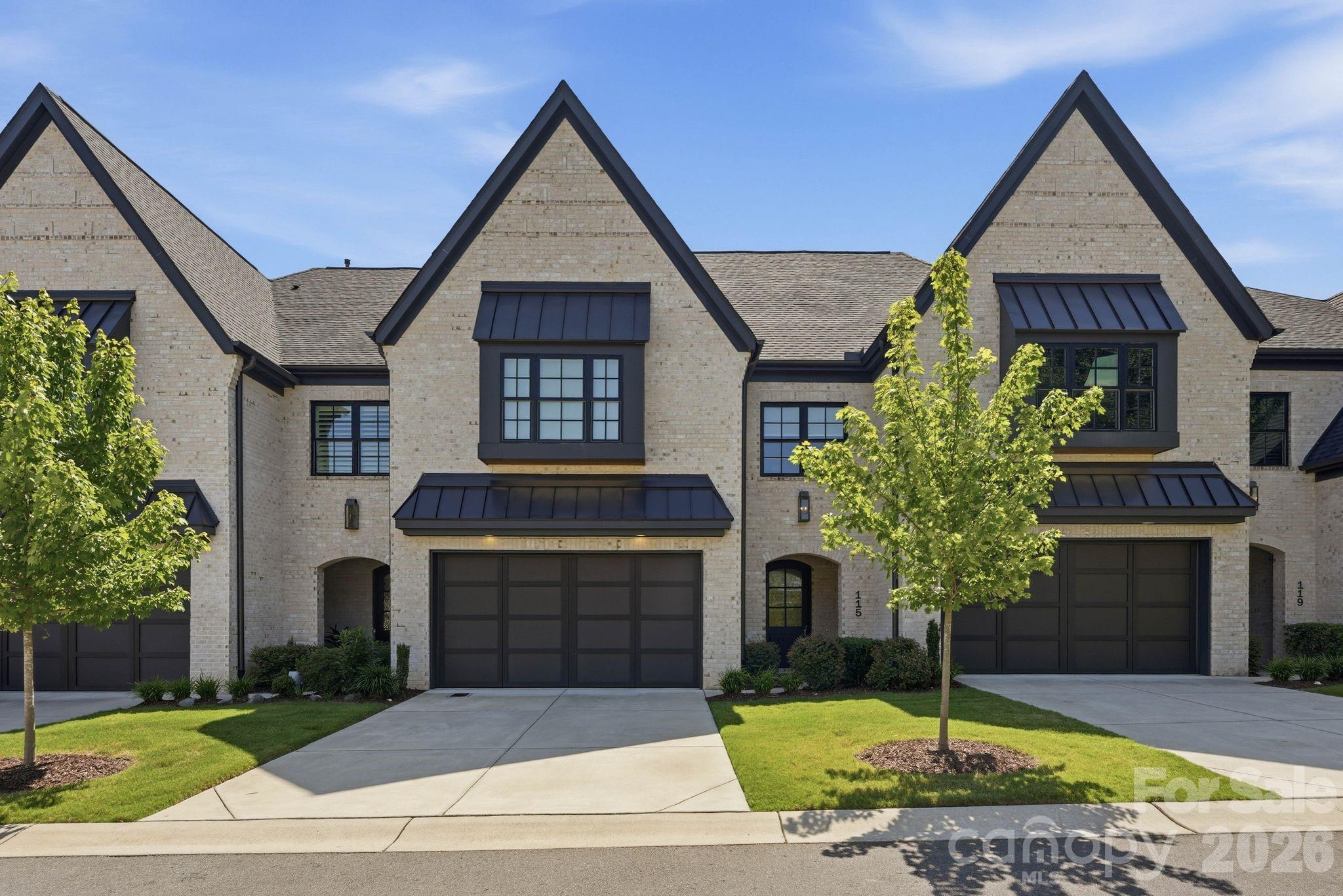 Welcome to 115 Thorncote Place, a stunning two-story townhome built in 2021 by Arcadia in the highly desirable Sutton Hall community, ideally located near Olde Providence with easy access to everything SouthPark has to offer. A spacious foyer with tall ceilings welcomes you into the beautiful family room featuring a stone surrounded gas fireplace, custom built-in shelving and cabinetry, and an open-concept layout. The chef's kitchen is appointed with high-end appliances, a large marble island, appliance nook, wine refrigerator, and a gas range with four burners and a griddle. The bright dining area overlooks the fenced backyard, while custom motorized blinds in both the family and dining rooms provide added comfort and privacy. Step outside to the covered bluestone porch and fenced backyard, perfect for relaxing or entertaining, with gated access to the street. The main level also offers a generous laundry room with sink, convenient drop zone off the attached garage, pantry, and abundant storage with three additional closets. Upstairs, a wide hallway leads to the expansive primary suite featuring an oversized custom walk-in closet and a luxurious bath with dual vanities and a walk-in shower with two built-in benches. Two additional bedrooms each include en-suite baths, and a versatile flex space with rubber gym flooring provides the perfect area for fitness, office, or play. Additional hallway storage completes this exceptional home.