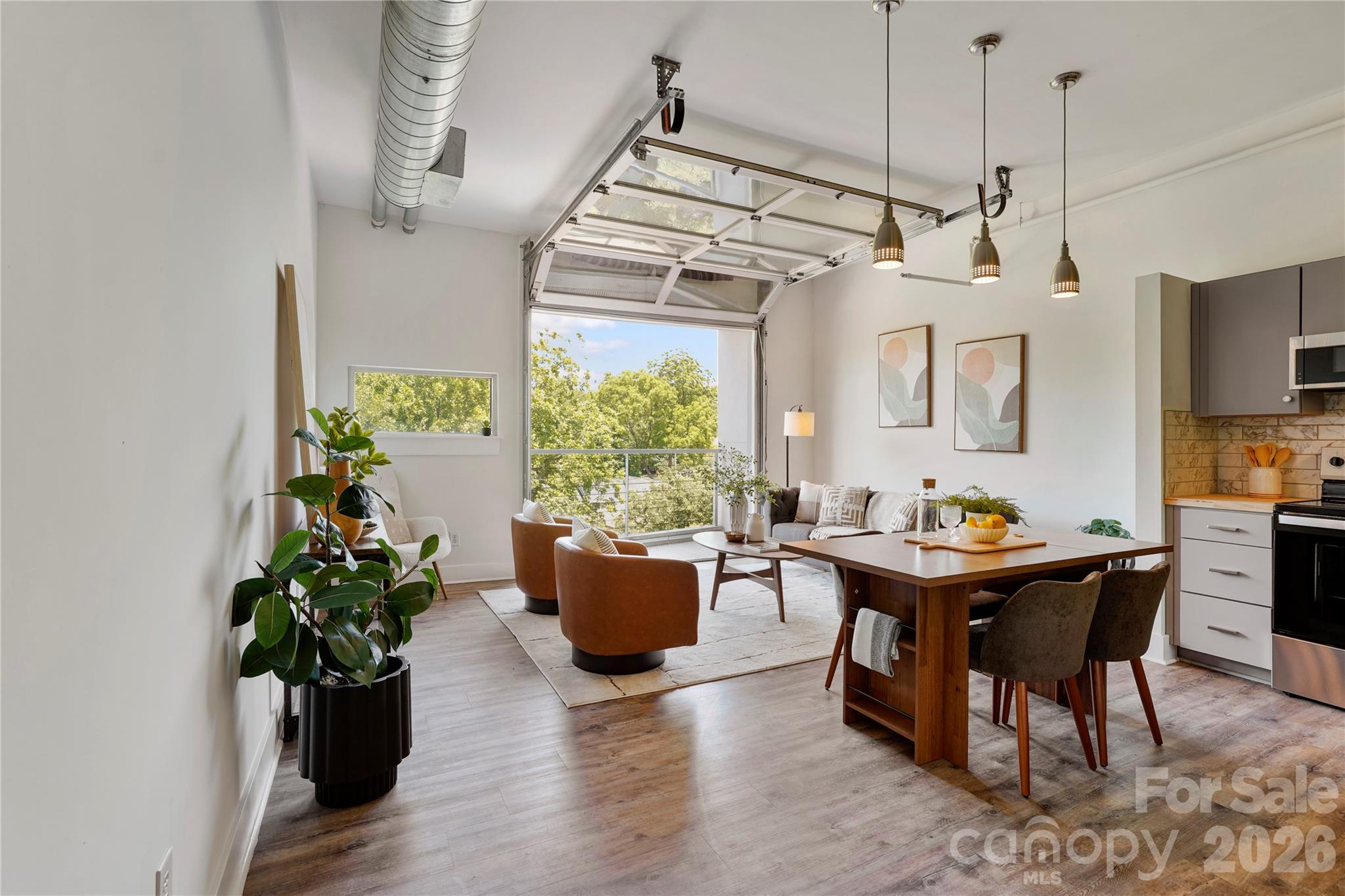 Located on the top floor of Central 27, this recently improved condo captures the unmistakable energy of Plaza Midwood with a design that feels both bold and effortless. Soaring 13-foot ceilings and exposed ductwork set the tone, while a full garage-style door opens from the main living space to a covered balcony, creating a seamless indoor-outdoor experience that’s as functional as it is striking.

The open-concept layout is designed for the way you actually live, whether that’s hosting, unwinding, or working from home. The kitchen has been thoughtfully updated with butcher block countertops, brand new stainless steel appliances, and a tiled backsplash that ties together the modern gray cabinetry with a clean, cohesive aesthetic.

The newly upgraded bathroom delivers a fresh, curated feel with a tiled walk-in shower, updated vanity, and a walk-in closet that adds everyday functionality.

Access is effortless with elevator service directly from the parking deck, and once you’re home, everything Plaza Midwood is known for is right outside your door. Local coffee shops, standout dining, eclectic retail, and a nightlife scene that keeps the neighborhood alive. The greenway, nearby parks, NoDa, and Uptown are all just minutes away.

Short-term rentals are permitted with a minimum stay requirement, offering flexibility for those considering part-time use or an investment opportunity.

This is not just a condo, it’s a front-row seat to one of Charlotte’s most dynamic neighborhoods.