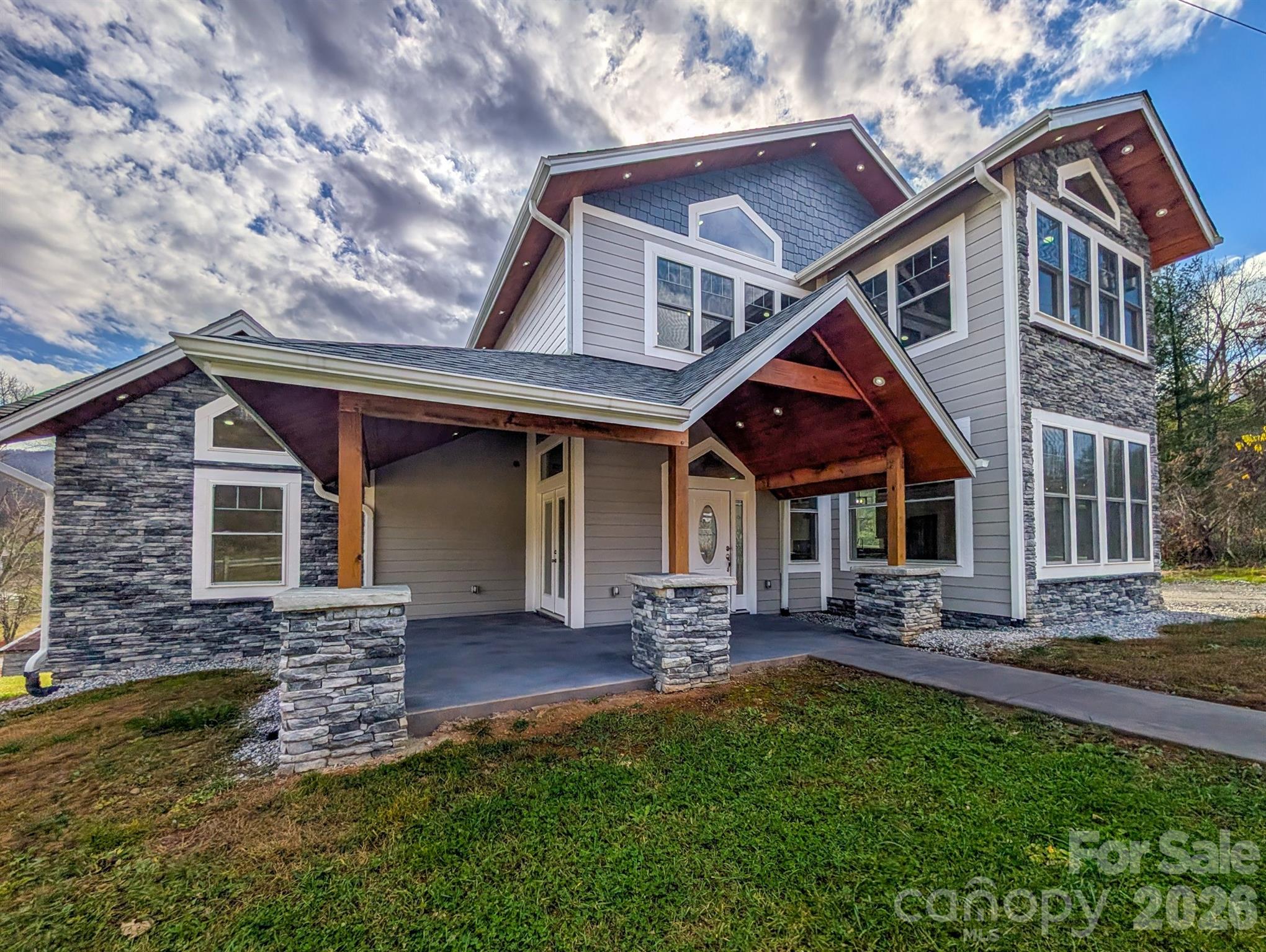 Discover exceptional craftsmanship and modern luxury in this high-end 4-bedroom, 3 full-bath + 2 half-bath residence, thoughtfully designed to accommodate both elegant living and business flexibility. Step inside to a bright open-concept main level featuring a welcoming foyer, chef’s kitchen with specialty appliances, a spacious dining area, and a comfortable living room that flow seamlessly together—perfect for entertaining or everyday living. The main level also includes two ensuite bedrooms, a half bath, laundry room, walk-in pantry, and under-stair storage. Upstairs, the open-concept Great Room serves as the heart of the home, centered around a stone fireplace that exudes warmth and character. You’ll also find a second laundry area, two additional bedrooms with walk-in closets, a dual-entry full bathroom, and a separate half bath for added convenience. Every feature of this home has been elevated for comfort and sophistication—heated bathroom floors, recessed lighting, WiFi-enabled smart switches with dimmers, smart-key door locks, power pop-up kitchen outlets with wireless phone chargers, specialty appliances, and a specially engineered roof system paired with extra foam insulation for superior sound and temperature control. (See attached full specification list for details.) With no zoning restrictions and direct access to a major highway, this property offers incredible versatility—ideal for a private residence, business, or a hybrid live/work setup. An additional 1.16 acres (originally acquired via NC DOT) is also available for purchase from the owner, providing even more opportunity to expand. Don’t miss this rare opportunity to experience quality craftsmanship, modern innovation, and prime location in one remarkable property. Schedule your private tour today!