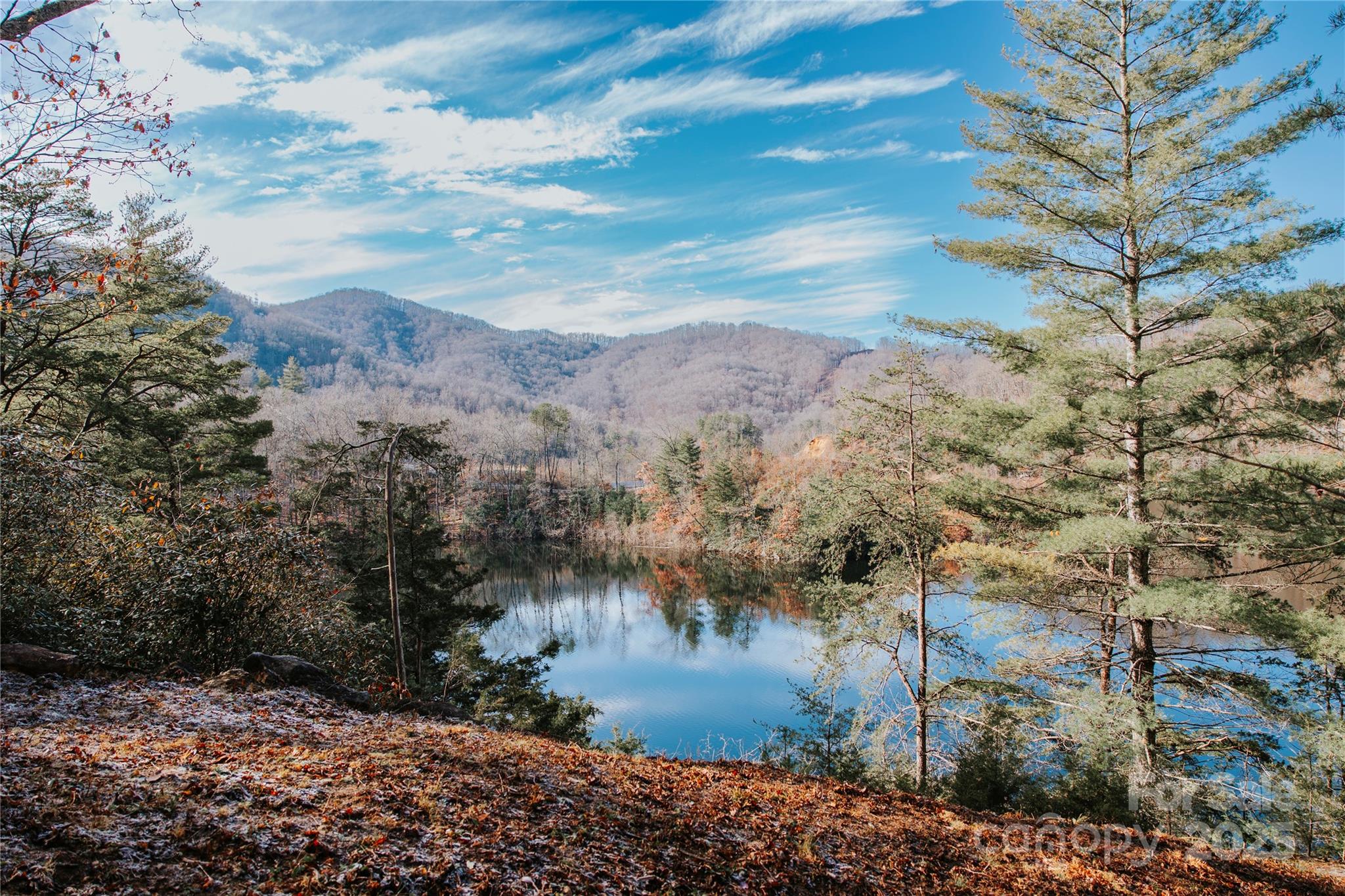 Discover one of the most desirable lakefront opportunities on pristine Cedar Cliff Lake! This stunning 2.22-acre homesite offers level terrain and spectacular water frontage—perfect for a vacation retreat, income-producing rental, second home, or year-round living. This ready-to-build parcel features a cleared house pad, 4-bedroom septic system already installed, well drilled, and underground utilities in place—saving you time and money.  Cedar Cliff Lake spans approximately 121 acres and 2 miles long, ideal for motorboating, paddling, fishing, and swimming. Anglers love the lake’s excellent largemouth bass fishing! Positioned right next to the neighborhood marina with a four-slip boat dock at the deep end of the lake, you’ll enjoy immediate access to the water—bring your boat and embrace the lake life. Conveniently located less than 15 minutes to WCU, 20 minutes to Sylva and close proximity to Cashiers, Waynesville, Cherokee and Asheville. One of best lakefront lots in Western North Carolina.