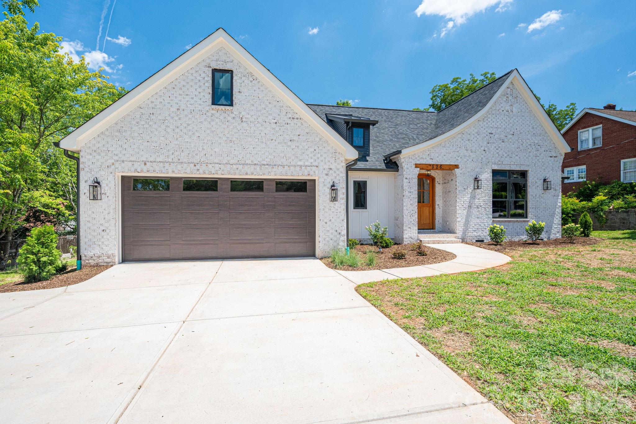 Welcome to this stunning New Construction, Modern French country-style home, perfectly situated in a vibrant neighborhood just steps from the area's best coffee shops, charming boutiques, acclaimed restaurants, and lively entertainment. Offering effortless access to everyday conveniences and weekend adventures, this home combines timeless curb appeal with high-end interior finishes for sophisticated everyday living.
The striking off-white brick exterior, accented by a dark gray shingled roof, black garage doors, and warm wooden entry door, creates an inviting first impression. A graceful curved walkway leads through thoughtfully landscaped front gardens to the covered porch, while the dormer window and gabled rooflines add architectural elegance.
Inside, the open-concept living spaces impress with soaring ceilings, rich wood beams, and abundant natural light. The heart of the home features a gourmet kitchen with a massive central island, off white and natural wood cabinetry, premium stainless appliances, including a 36" gas range and refrigerator, elegant pendant lighting, and a stylish tiled backsplash. It flows seamlessly into the great room anchored by a cozy fireplace with a substantial custom-built wooden mantel with a black leathered granite surround, and built-in shelving—ideal for relaxing or entertaining.
The formal dining area showcases a dramatic coffered ceiling with warm wood planking and oversized black-framed windows. A dedicated home office offers a sophisticated retreat with color drenched paneling, dramatic beamed coffered ceilings, and large windows that fill the space with light.
Luxury continues in the primary bath, featuring spa-like finishes with large scale tile walls, a spacious glass-enclosed shower with hexagonal mosaic flooring, and high-end vanities with leathered black countertops. The primary closet also features custom-built shelving. Additional conveniences include a well-appointed laundry room with off-white cabinetry, leathered black granite countertops, a utility sink, and eye-catching checkerboard flooring.
This New Construction home delivers move-in-ready appeal with premium details throughout: light wood flooring, designer lighting, and thoughtful layouts that maximize both style and functionality. Whether you're hosting gatherings in the open living spaces or enjoying quiet mornings in the sun-filled office, every corner reflects quality craftsmanship.
Don't miss this rare opportunity to own a beautifully appointed home in one of the most desirable location. Schedule your private showing today!