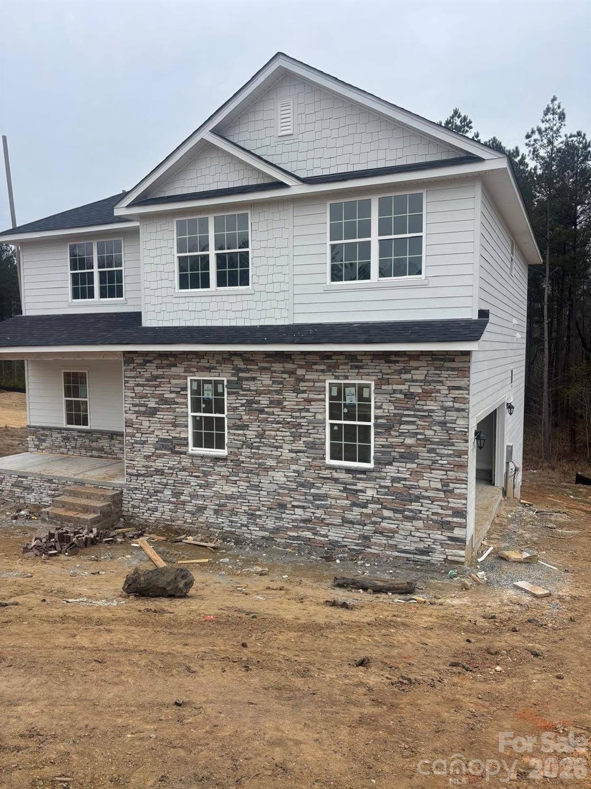 Beautiful home with finished walk-out basement in the highly desirable Lauren Pines community. Situated on a private 1-acre lot with protected tree-lined views. The main level features laminate wood flooring throughout, a formal dining room, and a spacious kitchen with a large island, quartz countertops, stainless steel appliances, and tile backsplash. Black iron stair spindles add an elegant touch. Generous walk-in closets throughout. Enjoy both a covered front porch and a covered back deck overlooking the peaceful wooded surroundings. The finished walk-out basement provides additional living, entertainment and flex space. Home has amazing back yard as well.  Don’t miss this rare opportunity for privacy and space in Lauren Pines. 3 bedroom /6 person septic with plenty of flex room options. 10K in FLEX Money, only $1000 deposit and closing costs paid with preferred lender.