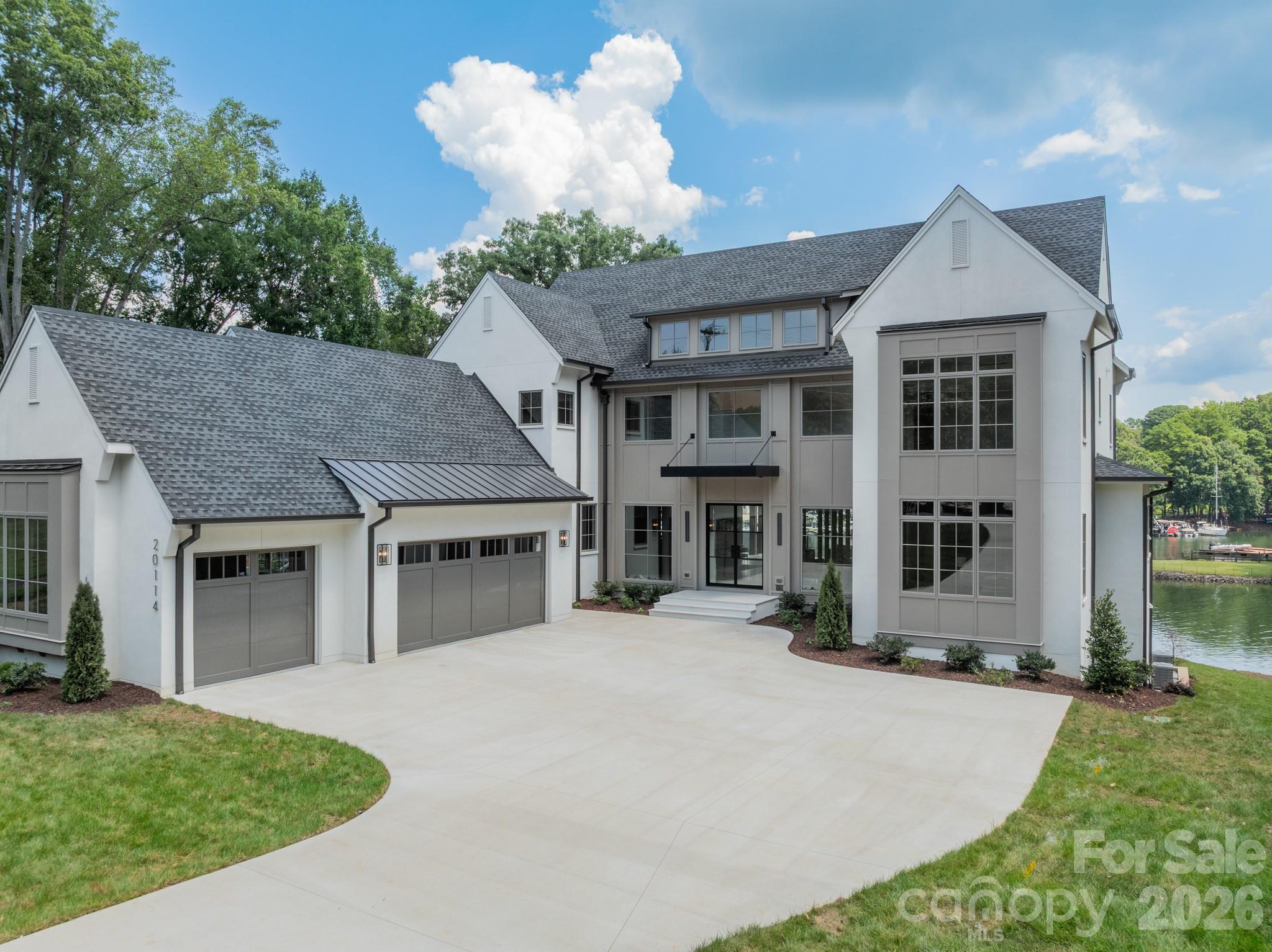Experience elevated Lake Norman living in this newly completed, custom-built lakefront estate by Eric John Builders, offering over 7,000 sq. ft. of thoughtfully designed living space. Created for effortless entertaining, the home features seamless indoor/outdoor living, a walk-out basement, and a private floating dock. Striking architectural woodwork, custom slatted details, warm natural finishes, and curated designer lighting define the interiors, while expansive glass walls frame tranquil lake views. The chef’s kitchen showcases top-of-the-line appliances, abundant storage, and a dramatic waterfall island. Everyday conveniences include laundry on every level, private ensuites, and custom walk-in closets throughout. The main-level primary suite serves as a serene retreat, completing a sophisticated lakefront residence where craftsmanship, comfort, and the Lake Norman lifestyle converge.
