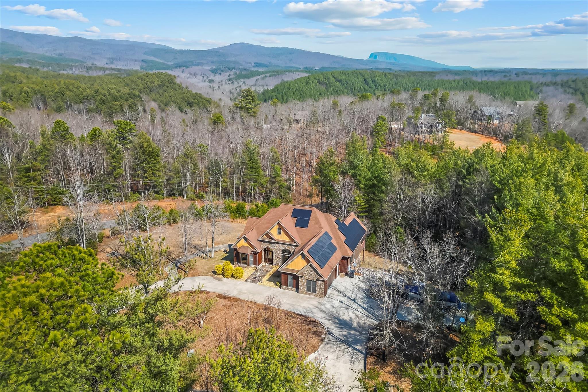 Recent home, well, and septic inspections — clean reports available. 11 Lake James homes went under contract in June. Owned 12 kW solar array + whole-home generator. Gated Bear Cliff community with long-range mountain views. Dedicated RV/boat parking + 5-minute golf-cart ride to Bear Cliff Marina.

A luxury mountain home priced to support a smooth relocation for the sellers, offering buyers a rare chance to step into a beautifully cared-for retreat at a price that reflects timing rather than the true cost to recreate it. Located in the sought-after Bear Cliff at Lake James gated community, the home’s thoughtful upgrades, long-range views, and easy access to the lake create a calm, effortless way of living. With ample boat and RV parking on site and Bear Cliff Marina just a five-minute golf-cart ride away, you enjoy all the benefits of lake life without the upkeep or expense of a waterfront property. It’s a warm, welcoming home where all of the major investments have already been made, allowing you to simply settle in and enjoy the lifestyle that draws people to Lake James.

The owned 12 kW solar array offsets approximately 85% of annual electricity usage, and may deliver up to $3,000 per year in savings every year while keeping the home comfortable in all seasons.

Your own private haven above Lake James sits on 2.13 wooded acres in the gated Bear Cliff community, offering long-range mountain views, mature trees, and the rare privacy of bordering protected federal land. Thoughtful upgrades throughout the property make everyday living easy and low-maintenance, with modern systems designed for comfort, reliability, and year-round efficiency.

A circular concrete driveway and native landscaping create a welcoming arrival, leading to multiple outdoor living spaces designed for year-round enjoyment. The wraparound deck, screened porch, and quiet seating areas offer peaceful places to take in long-range mountain and winter views—ideal for morning coffee, evening sunsets, or relaxing after a day on Lake James.

Inside, the home offers true single-level living with bright, open rooms and hardwood floors throughout. The chef’s kitchen features a Wolf gas cooktop, Café double oven, Sub-Zero refrigerator, island, and stainless appliances—an ideal setup for cooking, entertaining, or hosting family gatherings. The primary suite includes heated floors and a custom walk-in closet, while additional spaces such as the great room, dining room, breakfast area, office, media room, recreation room, and utility room provide flexibility for work, relaxation, and guests.

Behind the scenes, the property is engineered for comfort, efficiency, and long-term resilience. Systems include an owned solar array, whole-home generator, dual underground 500-gallon propane tanks, tankless water heater, radiant floor heating, heat pump, underground power, engineered drainage, lightning protection, well water, septic, and remote monitoring for key utilities. Together, these features deliver year-round reliability, reduced operating costs, and a level of infrastructure rarely found in Lake James homes.

The lower level adds a 500-bottle wine cellar and a large workshop with a roll-up door, ideal for tools, projects, or storage. An oversized concrete pad provides dedicated RV and boat parking.

Whether you’re spending the day on Lake James, exploring Pisgah National Forest, or relaxing on the deck, this home offers a private, comfortable, and well-designed retreat with modern systems that support a peaceful mountain lifestyle. Seller is flexible on closing date and requests a 30-day post-closing occupancy.