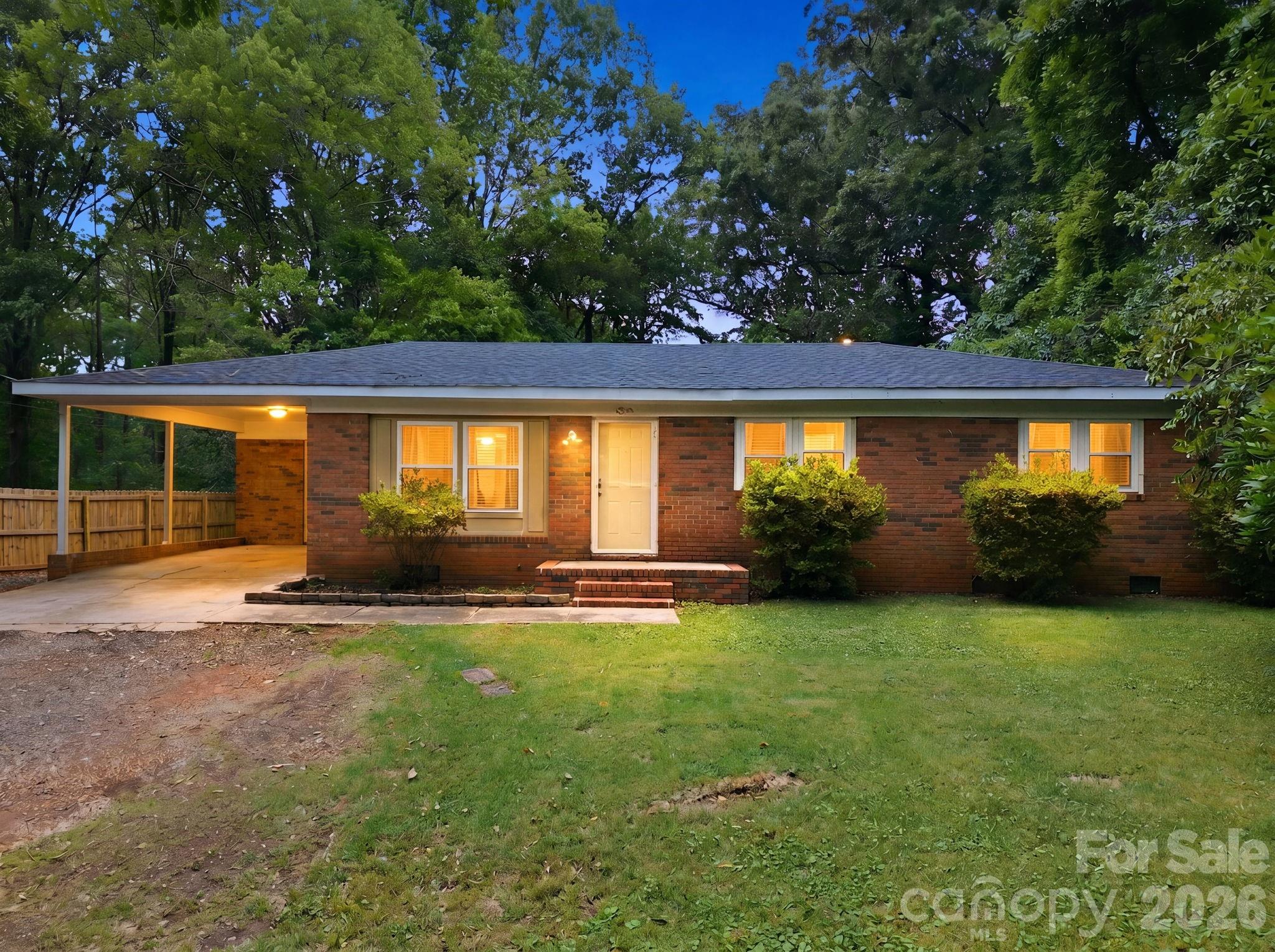 This well-maintained brick ranch is tucked away at the end of a quiet street, offering added privacy with access from both Shady Lane and Shinn Circle. Situated on a peaceful wooded lot, this 3-bedroom home features updated flooring, fresh paint, updated bathroom finishes, and a spacious kitchen with ample dining space for gathering with family and friends. The home has been well cared for. Enjoy the convenience of the attached carport with concrete parking area along with a gravel driveway and relaxing outdoor space surrounded by trees. The private backyard offers plenty of room for entertaining, gardening, or simply unwinding. Move-in ready and conveniently located near downtown Norwood & Lake Tillery, this home combines comfort, privacy, and functionality in one attractive package.