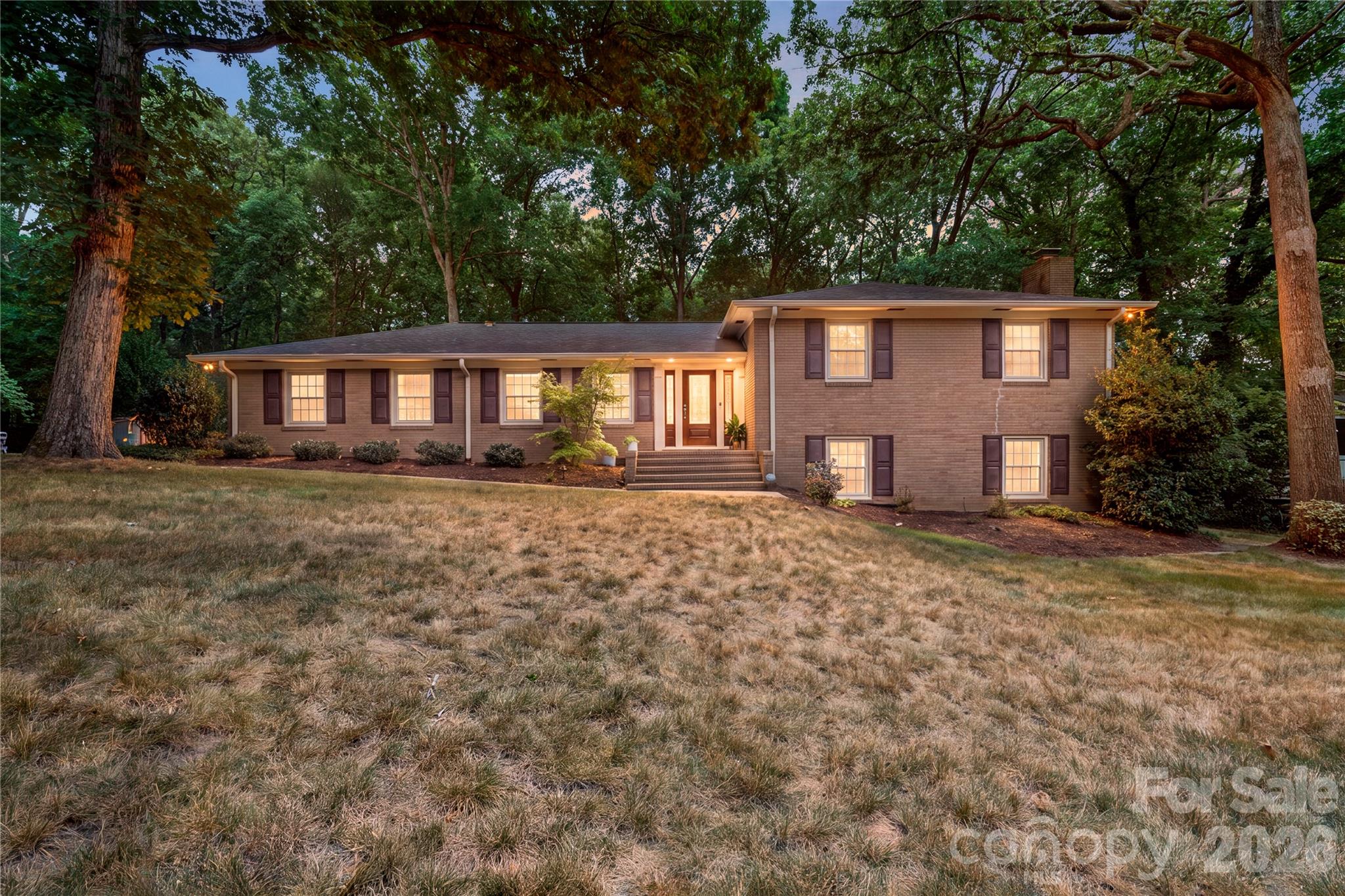 Sitting on almost 1 acre with No HOA, this beautiful & updated split-level home offers 5 bedrooms and 3 full bathrooms with a spacious and versatile floor plan designed for modern living. The open-concept main level features a tastefully renovated kitchen -- with a large island including breakfast bar, gas range, custom tile backsplash, quartz counters and abundant cabinetry -- flowing seamlessly into the dining and living areas. The lower level is home to a private primary suite with a newly renovated luxury bathroom complete with tile surround shower and  walk in closet with custom built-ins plus provides direct access to the pergola covered patio! The lower level is completed with a spacious family room featuring a gas fireplace and the laundry room for convenient living. On the upper level are four additional bedrooms including a second primary suite; making for a perfect in-law suite or private office space! The 3 secondary bedrooms are all generously sized and provide great additional living space or additional flex space as needed. The beauty and usability continues on the exterior; enjoy year-round outdoor living on the vaulted, screened and enclosed deck overlooking a private backyard with mature trees, a fire pit, wooded paths and storage shed. Recent updates include a new kitchen, added wine refrigerator to lower level, renovated primary bath and closet, HVAC, and roof. Additional highlights include a Tesla charging station, 2-car attached carport, and direct access to Wallace Park with tennis courts, trails, playgrounds  and recreation.