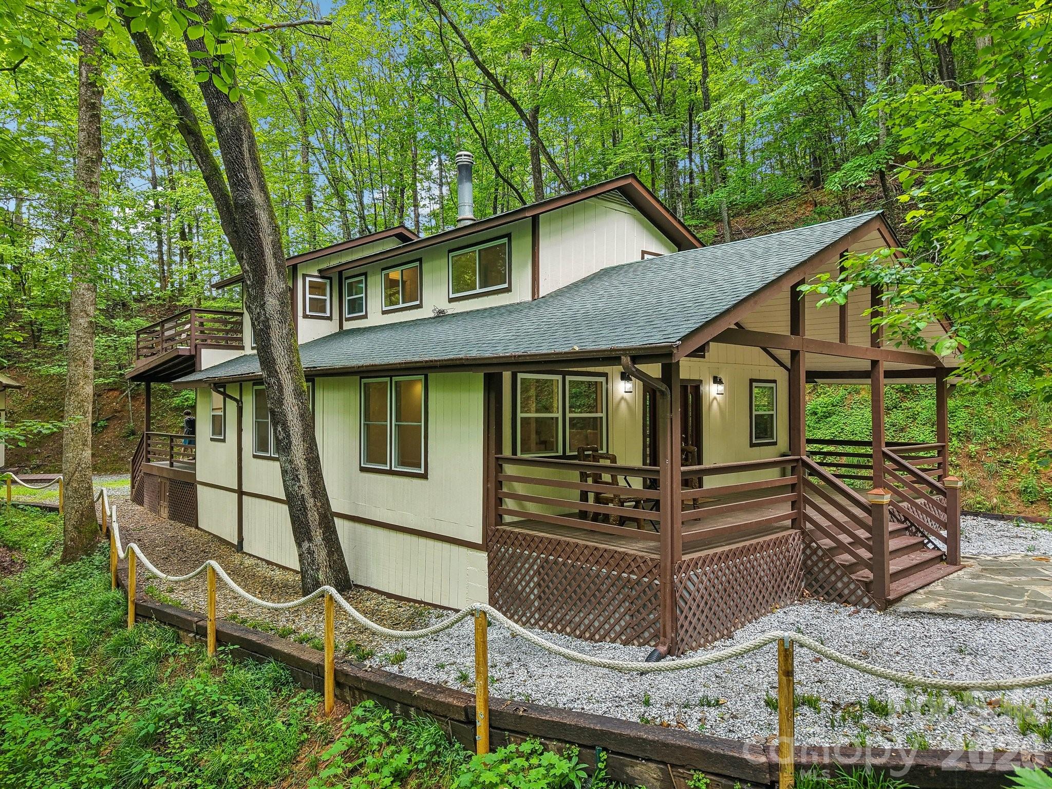 Fully reimagined mountain retreat in the heart of the Smokies, 291 Dills Rd offers the perfect blend of privacy, comfort, and versatility. Set on a peaceful wooded lot with seasonal mountain views, this 3BR/3BA home features approximately 1,495 sq ft of thoughtfully updated living space with a warm, modern rustic feel.

Step inside to find an open-concept living area with brand-new hardwood floors, exposed beams, and a cozy wood-burning stove. The kitchen is beautifully finished with sleek cabinetry, butcher block countertops, and a spacious island ideal for gathering. Each bedroom offers its own sense of privacy, with updated baths featuring tile showers and modern fixtures.

Outdoor living is where this property truly shines—enjoy the expansive covered decks, front porch, and private wooded setting perfect for relaxing or entertaining.

A standout feature is the separate 434 sq ft cabana/tiny home, complete with loft sleeping area, full bath, kitchen, and its own deck—ideal for guests, rental income, or a private retreat space.

Additional highlights include a newly added carport, paved access, and a serene setting just minutes from the Nantahala Outdoor Center, Appalachian Trail, Fontana Lake, and endless hiking and rafting opportunities. No HOA or restrictions provide flexibility for full-time living, vacation use, or short-term rental potential.

This unique mountain property offers a rare combination of charm, income potential, and proximity to Western North Carolina’s top outdoor destinations.
