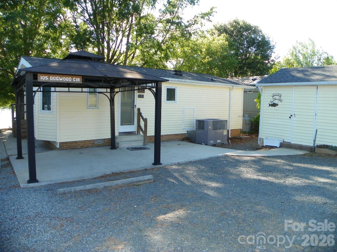 WATERFRONT-Property located in beautiful Gated(24 hr.)- Badin Shores RV Resort with Amenities for the entire family!!! AND Badin Shores own drop off and pickup mail room! Clubhouse with covered back deck-may be reserved by owners.  Make this YOUR permanent dwelling OR Lake Getaway- 2 Bedrooms, 1.5 baths, ceiling fans, eat at bar/kitchen, New stove and refrigerator remain. Great living room with a wall of windows/sliding doors to view beautiful Badin Lake!!! Covered (concrete) lakeside porch (items on the porch remain), Gazebo on road side- just sit and relax!! Storage building on the roadside -has washer/dryer in it remains. Just steps away from the Marina- Restaurant/boat launch/ boat slips and the beautiful sandy beach/picnic area.   Property comes with boat slip-134 H-30'. The slip is currently leased out by the owner till 3/15/27.
Extra Parquet flooring in the storage building, extra Vinyl siding under house. A little TLC and make this YOUR retreat !!  No gas tank-owner carries his own gas for heating.