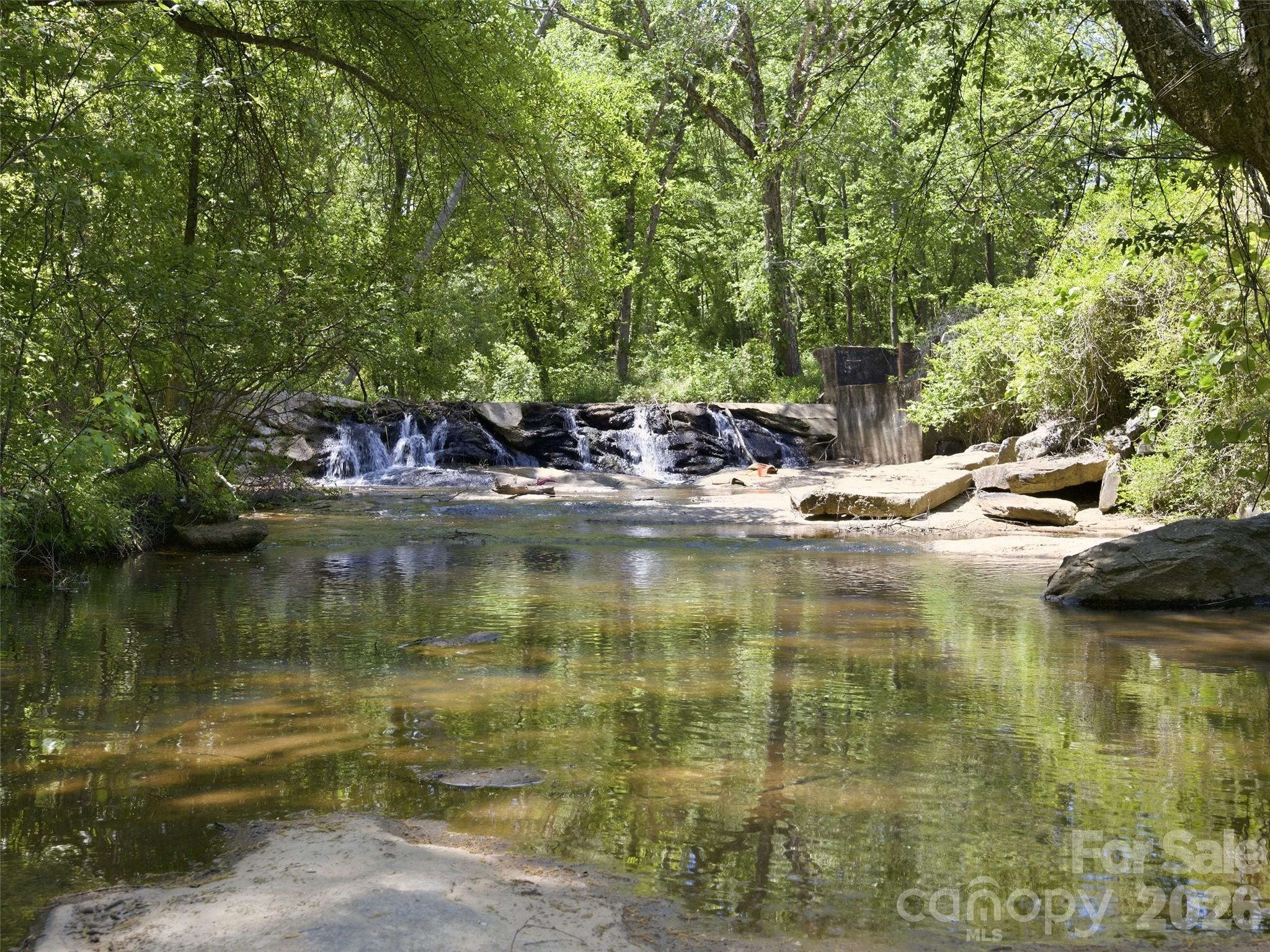 Nearly 5 acres in Forest City with a home, additional parcel, and a natural flowing creek! If you’ve been looking for space, privacy, and something truly special, this property delivers. The 3-bedroom, 1.5-bath home is situated on 1.06 acres and offers a functional layout with comfortable living space, while the adjoining 3.79-acre parcel brings the total to approximately 4.85 acres. The land features a mix of open areas and wooded privacy, along with a natural flowing creek, existing paths, and a cleared space that make it easy to envision building, expanding, or simply enjoying the land as it is. Zoned R8 Residential, the property offers potential for an additional homesite or future subdivision, subject to approval. A rare opportunity in a private setting, just minutes from downtown Forest City.