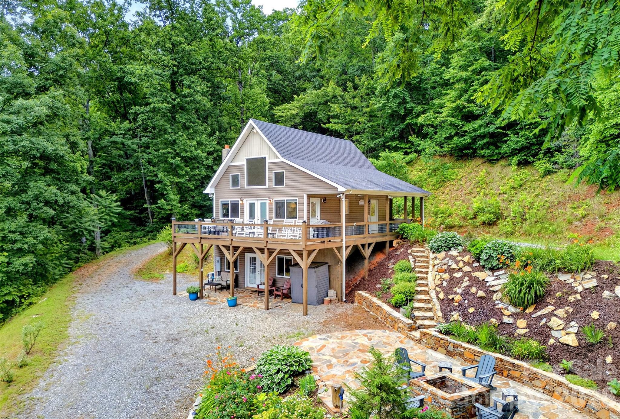 Just bring your toothbrush to this lovely, fully-furnished mountain home that is truly move-in ready! This property sustained zero damage from Helene and is immaculate inside and out. Enjoy fabulous mountain views from the porch, deck, or one of the beautiful stone patios, complete with a fire pit. Relax with a glass of local wine or craft beer while surrounded by blooming gardens and peaceful mountain scenery.

Inside, the home is modern and cozy, featuring two bedrooms, two bathrooms, a flex room, and the same amazing views as outside. Located just outside of Gateway Mountain, this property has no POA fees or restrictive bylaws. The land is well-excavated with plenty of room to add another building. Quality is evident throughout, and you are only a few minutes from downtown Old Fort and I-40. A true gem, you won't be disappointed.
Most furnishings available for sale.