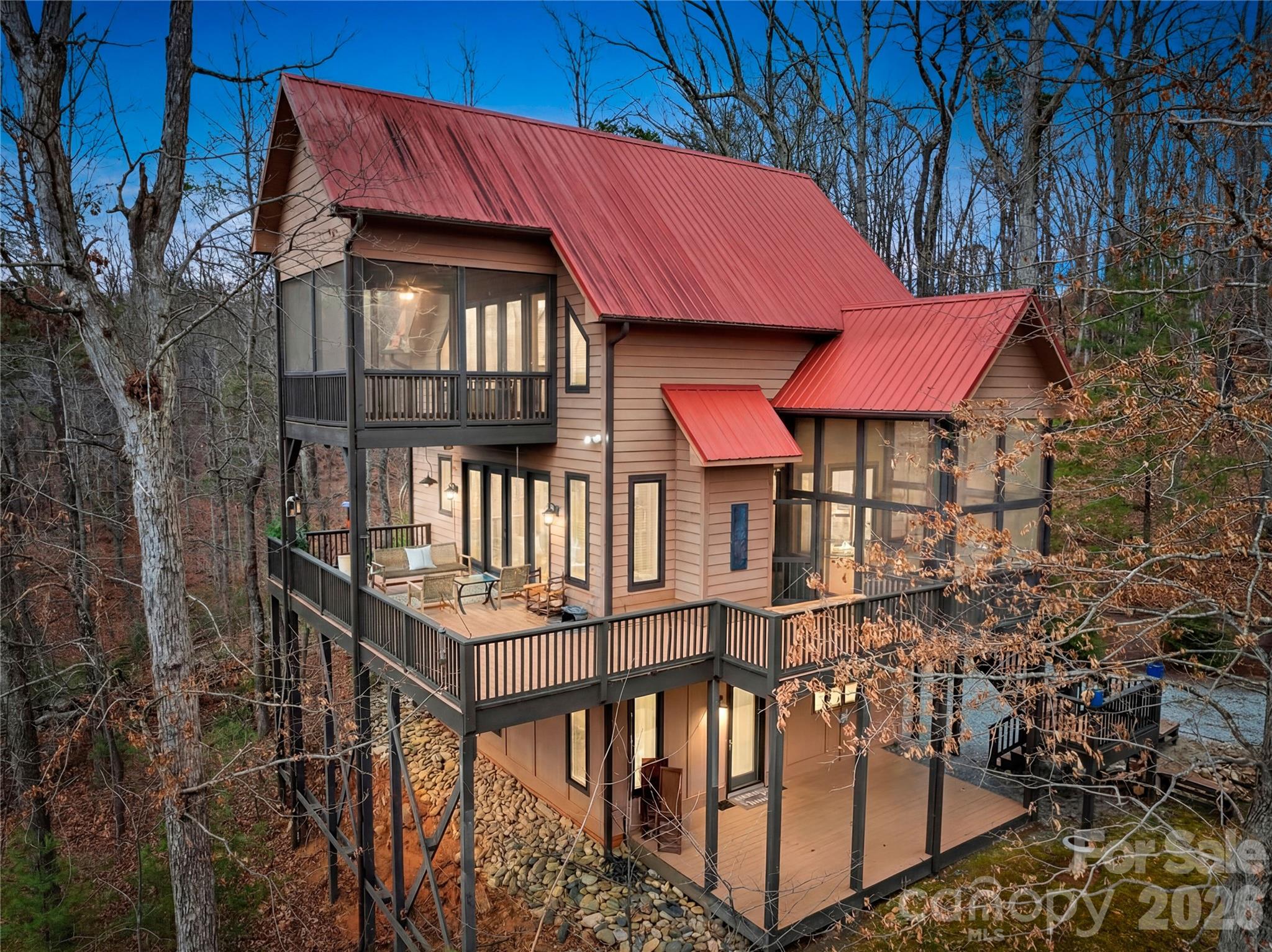 Nestled above the protected Green River Gamelands, this high-end luxury home offers a rare blend of refined interior living and effortless outdoor lifestyle. With preserved forest land stretching out beyond every deck and porch, breathtaking views await every moment of the day.

From the moment you step inside, the open concept main level draws natural light deep into the home. Expansive casement windows and 7' french doors provide abundant natural light. The kitchen features top-tier stainless steel Kenmore appliances, quartz countertops, and a dry bar with a dedicated wine fridge. The living room anchors the space with a river rock gas log fireplace and french doors that lead out to a wrap-around deck, offering covered retreat and open-air living, with the Gamelands as your seasonal backdrop.

Throughout the home, an intentional mix of wood textures adds warmth and character at every turn, layering together to create a tastefully curated and organic interior.

Wake up to morning light filtering through the primary bedroom windows, the warmth of red oak hardwood underfoot, and the quiet glow of the fireplace just steps from your bed. French doors open to a private screened sleeping porch where tree canopy views make the outside feel like an extension of the room. The spa-like primary bath features a jetted garden tub beneath a beautiful oversized window, a walk-in rain shower, and heated floors. This is a room you will not want to leave.

This is a home that lives as well outside as it does in. Enjoy complete privacy in your wooded paradise, with direct trail access to the Gamelands, fenced area for pets, and low-maintenance yard in desirable Piney Mountain community.

3 previous lots were combined to make up the property.  This is a portion of the deed recorded in Polk County Register of deeds (just 2 lots).  A third lot is available if the buyers would like 7+ acres.