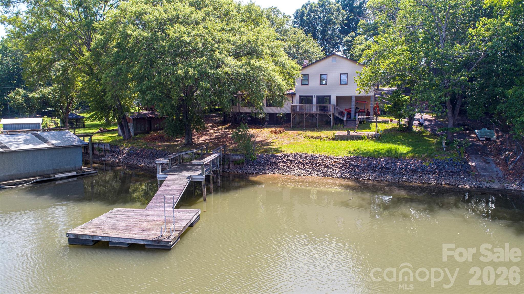 Welcome to this 4-bedroom, 3-bathroom waterfront retreat on the Charlotte side of Lake Wylie, offering stunning views and an unbeatable location just minutes from Fort Mill, Tega Cay, and I-77. This property is a boater’s dream, featuring a solid seawall with rip rap, two piers, a floating dock, and a floating boathouse with boat ramp ready for your personal touch. A newer HVAC system adds comfort and peace of mind, while the impressive 1,000 sq ft detached shop (25x40) with a large roll-up door 12x14  offers incredible space for storage, hobbies, or a workshop. Whether you’re looking to update and personalize or invest in a rare lakefront opportunity with approximately 198ft of shoreline, this home delivers the location, water access, and space that’s hard to find. Come see the potential for yourself and schedule your showing today!