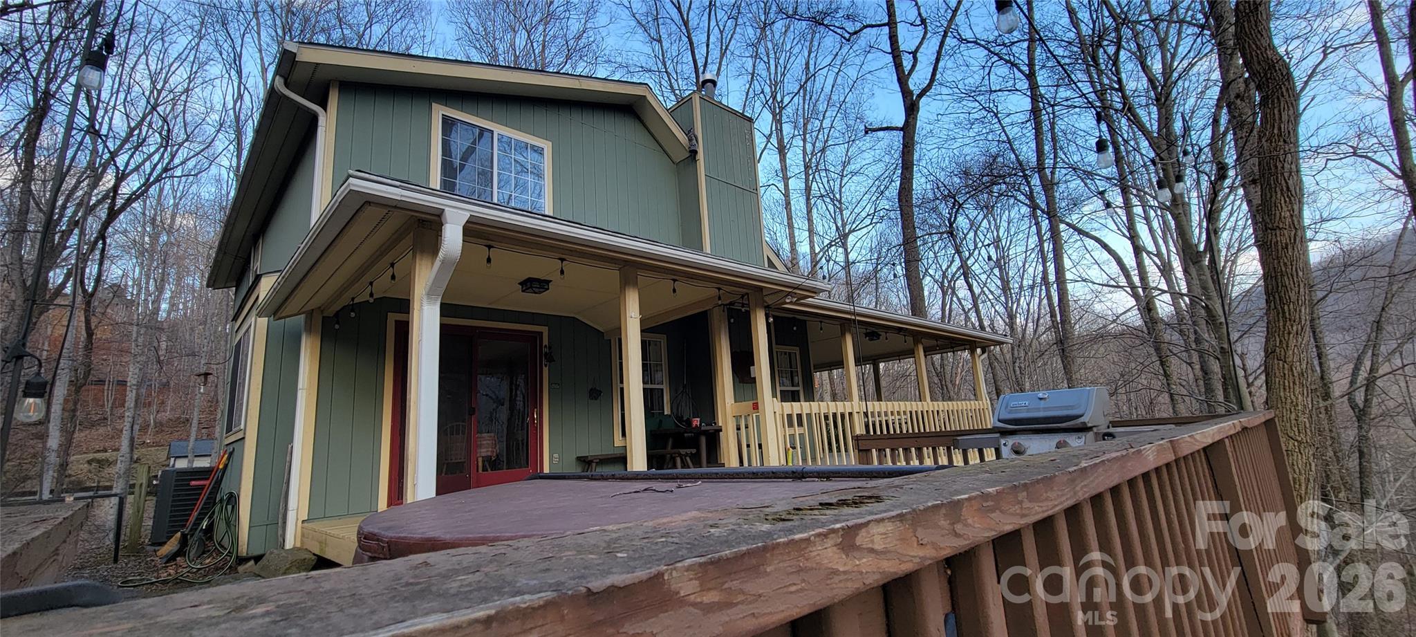 LOCATED on two lots inside MAGGIE VALLEY COUNTRY CLUB ESTATES - This 2 Br/2 Bh with loft, turn key/completely furnished mountain cabin with wrap-around porch & deck for hottub. Greatroom with gas log FP. Primary bedroom on main level, central heat & air.  This 2 story home sits on 2 lots being a total os 1.76 acres. Experience the artificial waterfall sounds near private rear porch with mountain views.  Additional views can be had with add'l tree trimming or cutting.  Greatroom area has high vaulted wood ceilings, central heat & air. All paved easy access.  The atmosphere will provide guests with a true mountain getaway feel.  Outstanding rental history makes this a perfect investment opportunity in the heart of the popular tourist destination of Maggie Valley - Waynesville NC area.  A wonderful choice for your primary or vacation home.  Maggie Valley Country Club membership amenities available if desired, including golf, swimming, tennis and dining.  Located approximately 5 minutes from downtown Maggie Valley and 10 minutes to beautiful Lake Junaluska and downtown Waynesville with shopping, fine dining, festivals, etc.