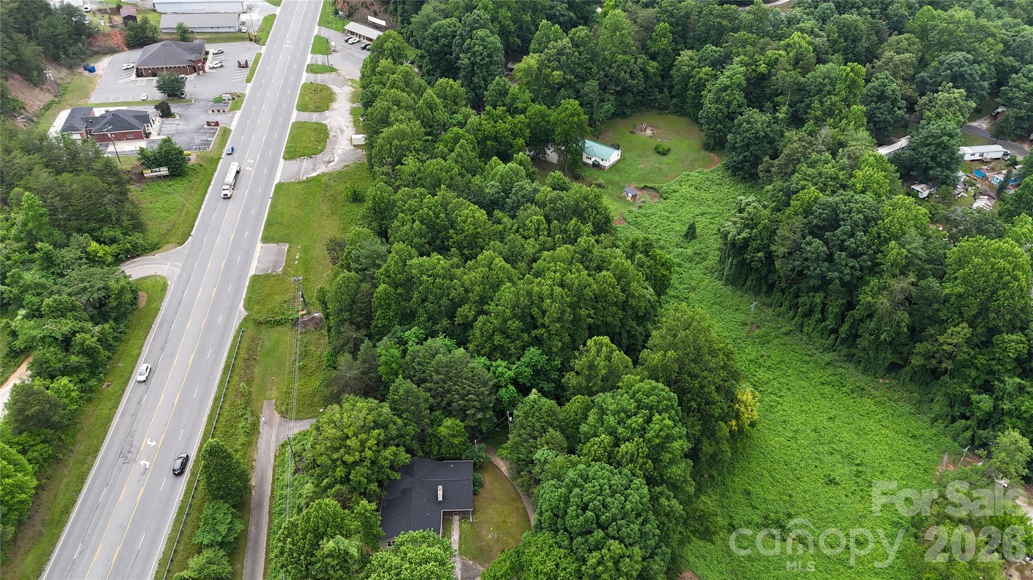 Room to build. Room to breathe. And a location that puts Western North Carolina at your doorstep.
This 0.77-acre homesite — the larger of two newly created parcels just outside Marion, NC — offers a generous building envelope with the rare advantage of city water and sewer already accessible. No HOA, paved road frontage via US 221, and a shared private drive providing secondary access make this a genuinely ready-to-develop opportunity in a market where buildable lots are increasingly hard to find.
The lot's natural topography gives it character. With some slope to the terrain, a thoughtful home design can take full advantage of the elevation — think covered porches, a walk-out basement, or elevated views that a flat lot simply can't offer. Buyers who've built on sloped land in WNC know that grade often creates the most interesting and livable homes when worked with rather than against.
It's worth noting that a power line easement runs along the side of the property. This is reflected in the recorded plat and should be factored into your site and home placement planning — your builder or designer can help you work with the lot layout to maximize the usable footprint.
City water and sewer access eliminates two of the biggest hurdles on rural land — no perc tests, no well installation, no septic system to engineer. That means a cleaner, faster, more predictable path from vacant lot to finished home.
The location is one of this property's strongest suits. Minutes from downtown Marion's restaurants, shops, schools, and healthcare, and just a short drive from Lake James — one of WNC's most beloved recreational destinations. Boating, kayaking, fishing, hiking, and some of the most scenic mountain and water views in the region are practically in your backyard. Pisgah National Forest, Linville Gorge, and the Blue Ridge Parkway round out an outdoor lifestyle that draws people to this area from across the country.
If you're ready to build now or securing land for what's next, this parcel delivers meaningful acreage, public utilities, and a mountain location that's hard to replicate at this price point.
Your next chapter starts here.
