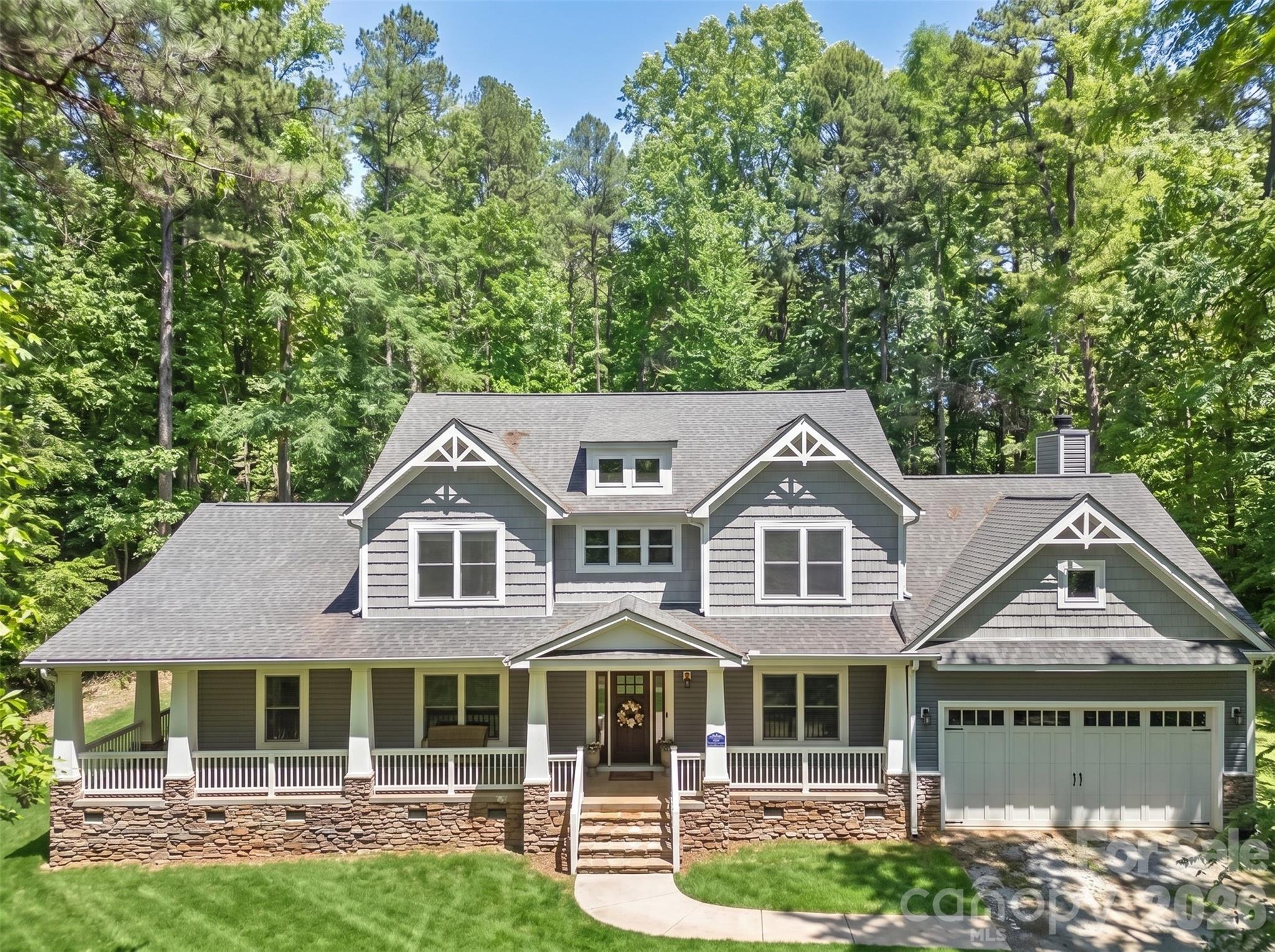 Welcome to 10200 Kerns Rd — a rare opportunity to own a custom-built estate on over 5 acres in Huntersville with no HOA. Built by Schumacher Homes in 2018, this property offers a unique combination of privacy, functionality, and upscale living with thoughtfully designed interior spaces and exceptional outdoor amenities.

A covered wraparound front porch extends across the front and side of the home, offering additional outdoor living space and a welcoming entrance to the property. Inside, the home features a spacious layout with a main-level primary suite with dual walk-in closets, a dedicated theater room, and an upstairs loft area complete with a wet bar, creating an ideal secondary living and entertaining space.

The gourmet kitchen is designed for both everyday living and entertaining, featuring custom cabinetry, premium finishes, a large island, built-in refrigerator, pot filler, Capital Connoisseurian professional-grade dual oven gas range, indoor grill, and Vent-A-Hood ventilation system. The open-concept layout flows seamlessly into the main living and dining areas, creating a comfortable and functional design throughout the home. New carpet installed in Summer 2025.

Outdoor features include a saltwater pool with a hot tub, three waterfall features, jumping ledge, and sun shelf lounging area with Sunbrella, along with a covered outdoor living area, outdoor shower, and half bath. A detached 30x40 workshop provides exceptional flexibility for storage, hobbies, recreational vehicles, workspace, or other flexible uses. The property also includes a pond and is surrounded by mature trees and expansive acreage, offering a private setting rarely found in Huntersville.

This property offers the space, flexibility, and amenities to accommodate a wide range of lifestyles while providing the privacy and setting that make estate-style living so desirable.