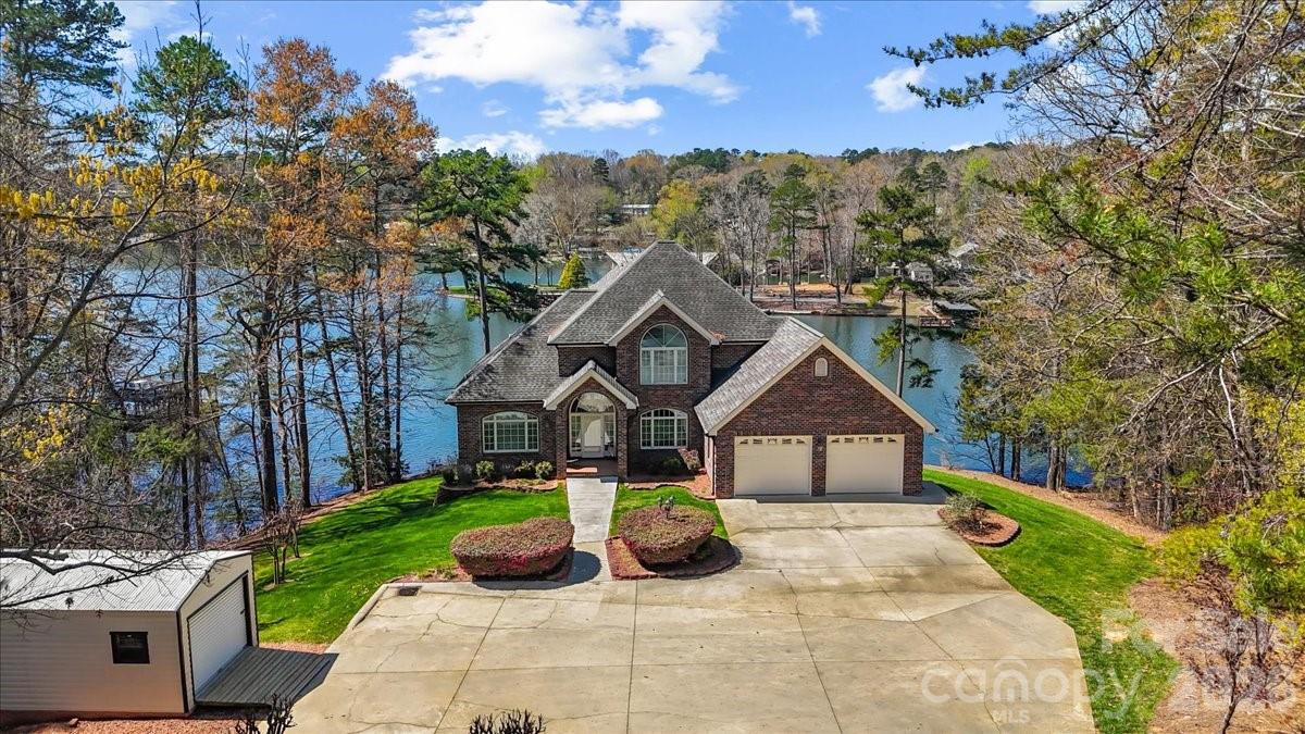 Welcome to your private waterfront oasis on beautiful Badin Lake! Nestled on over 2 acres, this stunning all-brick home offers the perfect blend of space, comfort, and lakefront living. Featuring 5 bedrooms and 3.5 baths, this home is designed for both relaxation and entertaining. Enjoy breathtaking water views from multiple living spaces and unwind in a home that comes mostly furnished—making your transition to lake life effortless. Step outside and experience everything waterfront living has to offer. Your private double-deck pier is ideal for soaking in the views, while the personal watercraft drive-on docks make lake days simple and convenient. A private boat ramp and basement garage provide easy boat storage and quick access to the water. Additional features include a 2-car garage, expansive outdoor space, and the privacy that only a 2+ acre waterfront property can provide. *lower level bedroom does not have a window -