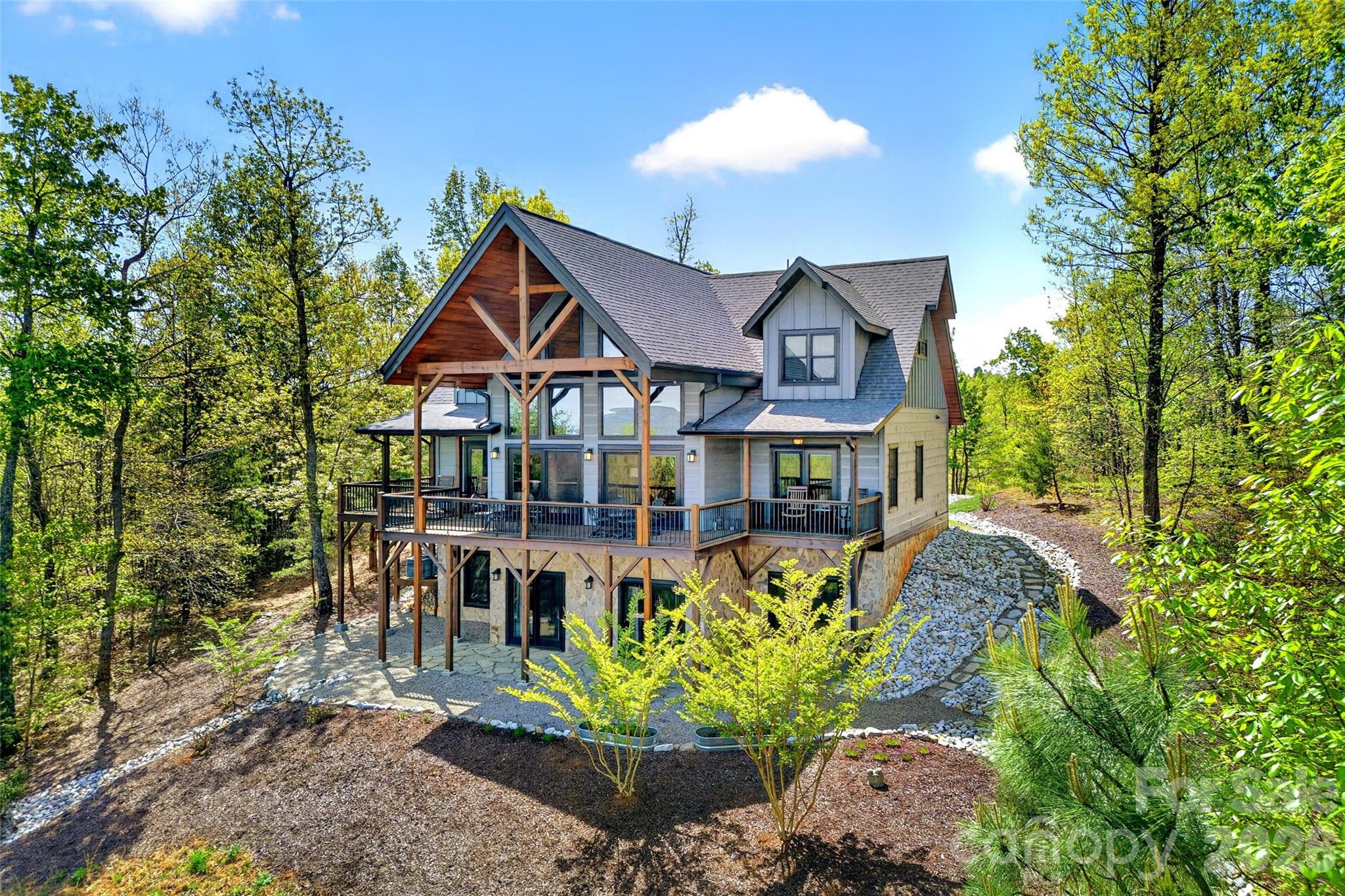 Perched high in the gated mountain community of Grandview Peaks, this exquisite 4-bedroom, 3.5-bath home offers some of the most breathtaking long-range views in Western North Carolina. From sunrise to sunset, enjoy sweeping vistas of Linville Gorge, Shortoff, Table Rock, Hawksbill, and the surrounding mountain ranges—with Sugar Top Resort visible in the distance on clear days.
The main level is thoughtfully designed for both everyday living and entertaining, featuring an open two-level great room anchored by expansive windows that perfectly frame the incredible mountain view. A spacious open kitchen and dining area flow seamlessly into the living space, while covered front and back porches provide the perfect setting to relax and take in the mountain air year-round. The primary bedroom suite is conveniently located on the main level, along with a laundry room and half bath.
Upstairs, a cozy loft overlooks the great room and serves as an ideal reading nook or office space, accompanied by two bedrooms and a full bath.
The walk-out lower level offers exceptional flexibility, featuring a fourth bedroom, full bath, den or recreation room, bonus room, and abundant storage—perfect for guests, multigenerational living, or a private retreat.
A detached two-car garage adds both functionality and convenience, offering ample space for vehicles, storage, or outdoor gear.
Grandview Peaks is a premier gated mountain community known for its natural beauty and amenities, including walking trails, a community lake, recreation area, and a covered pavilion with fireplace and outdoor kitchen. Centrally located between Morganton, Marion, and Rutherfordton, this home delivers peaceful mountain living with easy access to surrounding towns.
This is a rare opportunity to own a refined mountain retreat where extraordinary views, privacy, and comfort come together seamlessly.
