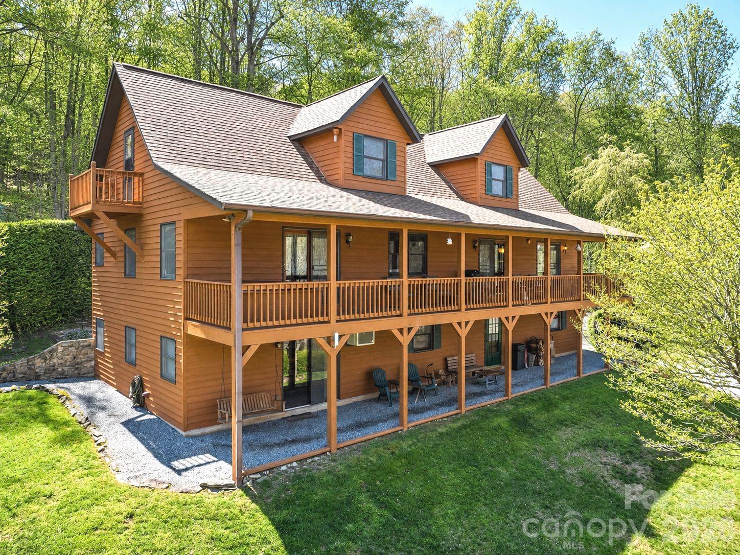 A Rare Mountain Oasis: Pristine Main Estate with Two Income-Producing Cabins. Discover a unique opportunity to own a meticulously maintained mountain retreat spanning 2.19 acres at an elevation of approximately 3,300 feet. Showcasing beautiful landscaping and magnificent old trees, this property is in truly incredible condition. The estate features three distinct homes, mountain views, a versatile two-story barn, and the tranquil sounds of Johnson Branch Creek. ***MAIN HOUSE (89 Stump Lane - Private Residence) Serving as the property's centerpiece, this private home offers 3 bedrooms and 3.5 baths. Living Spaces: A dramatic two-story great room welcomes you with gorgeous tongue-and-groove ceilings and hardwood floors. Kitchen & Dining: The kitchen features convenient pass-throughs to both the dining and living areas. Primary Suite: The spacious main-level primary suite includes an ensuite bath. Additional Main Level Features: Enjoy a large laundry room with pantry space, a dedicated office area, and a full-length covered porch complete with a hot tub. Upper Level: Features a large loft overlooking the great room, an additional bedroom, and a full bath. ***LOWER LEVEL APARTMENT: A fully finished walk-out apartment provides a covered deck, a kitchen, a full bath, and an expansive 22x20 open living/sleeping area, complemented by a mudroom, a utility room, and an attached two-car garage. The Rental Cabins: fully furnished currently available for short-term rentals. ***HONEYMOON CABIN (41 Stump Lane):  Bordering the creek, this charming 1-bedroom cabin includes an additional sleeping loft and a bath featuring both a shower and a jacuzzi tub. The interior boasts hardwood floors and a cozy wood-burning stove. Outdoor amenities include a covered porch with a hot tub and charcoal grill, plus a creek-side picnic table, park bench, and fire pit. Thoughtful updates include a 2016 roof, a Trane mini-split added in 2017, and supplemental wall heaters. Crawl space encapsulated 2021. ***JOHNSON BRANCH CABIN (46 Stump Lane):  This inviting 2-bedroom, 2-bath cabin features a great room with exposed beams and a wood-burning fireplace. Accommodations include a large primary ensuite and a second full bath with a private entrance, supplemented by a sleeper sofa and recliner. Guests can enjoy peaceful mountain surroundings and the sounds of the nearby brook from the covered porch and private hot tub. Features a 2017 heat pump and central air, a washer/dryer, and a crawlspace encapsulated in 2021. ADDITIONAL AMENITIES:  The BARN: A 27x27 (784 sq. ft.) two-story metal-roofed barn includes a bathroom, offering the perfect space for a workshop, hobbies, or extra storage. PICNIC AREA: table with benches and firepit along the creek.