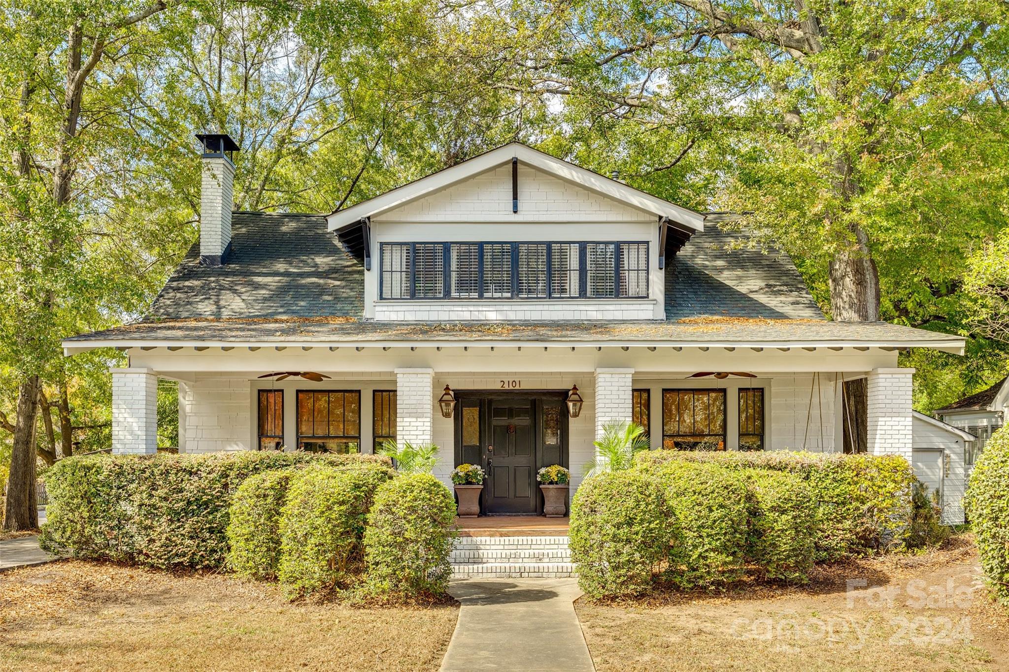 Experience the timeless charm of this Classic Craftsman gem nestled in the heart of one of Charlotte's most prestigious historic districts, Plaza Midwood. Preserved historic details seamlessly blend with modern luxuries, exemplified by the vaulted owner's suite adorned with repurposed original wooden beams. Relax in the sitting room where a majestic mantle and hearth invites you to enjoy a wood burning fire. Elevate your entertaining in the spacious eat-in kitchen, where three sets of French doors provide direct access to a secluded courtyard. Immerse yourself in the tranquil ambiance enhanced by the soothing sounds of a Charleston-inspired fountain, a 'She-shed' retreat, and enchanting market lights. Situated on a generously-sized corner lot with a circular driveway. Here, you don't just own a beautiful home; you become a custodian of Charlotte's illustrious history.