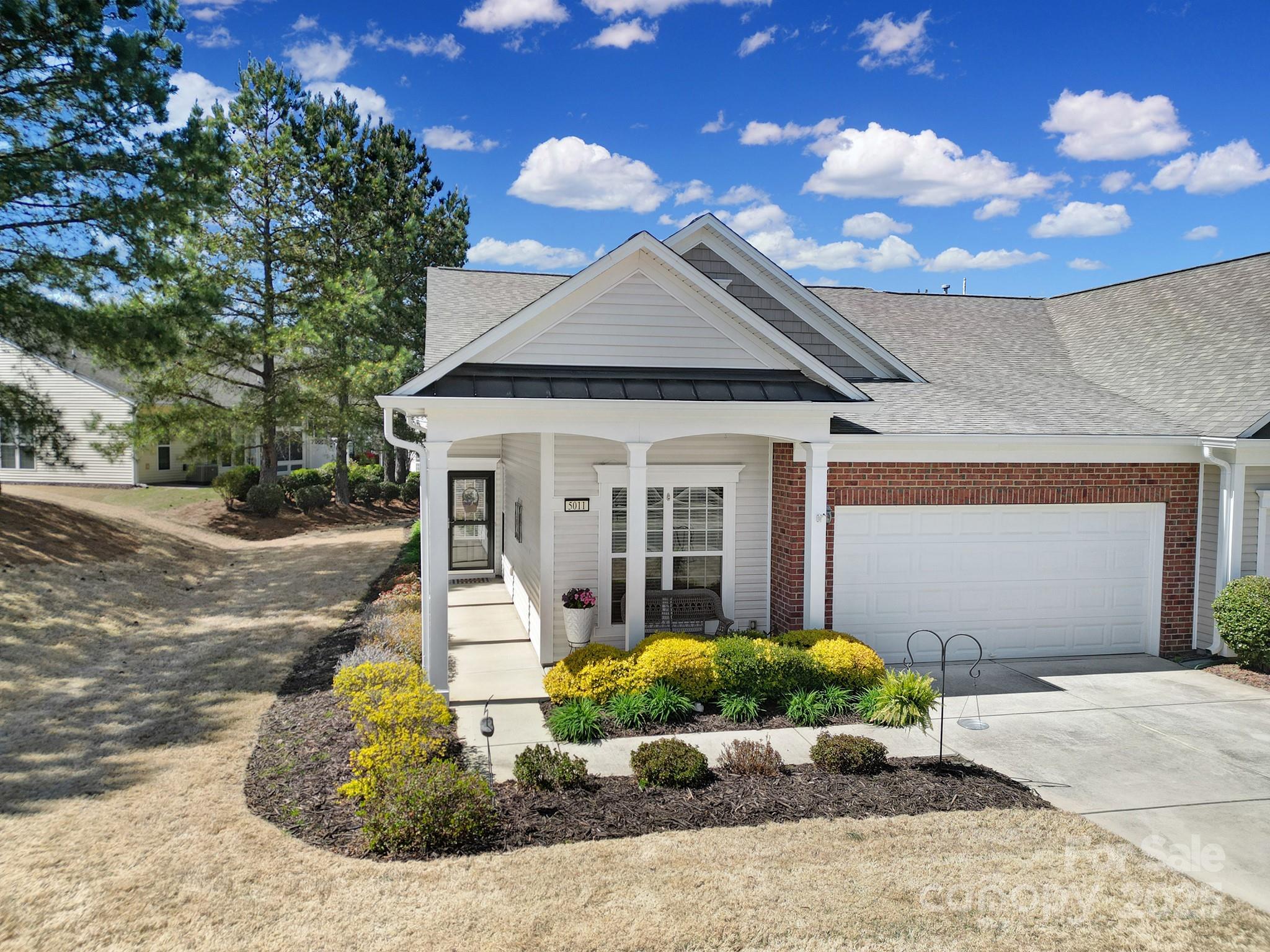 This beautifully maintained Muirfield Villa presents an ideal blend of comfort and convenience. Step inside to find a dedicated office, followed by a bright and airy living room with hardwood floors and abundant natural light. The pass-through kitchen and open dining area flow seamlessly, perfect for entertaining. Relax in the 3-season room, which opens to a quiet patio. The primary suite features a generous ensuite bath and walk-in closet, while a guest bedroom and bath provide comfortable accommodations. A two-car garage adds convenience. Nestled in Sun City Carolina Lakes, residents enjoy access to a golf course, amenity centers, pools, and more.