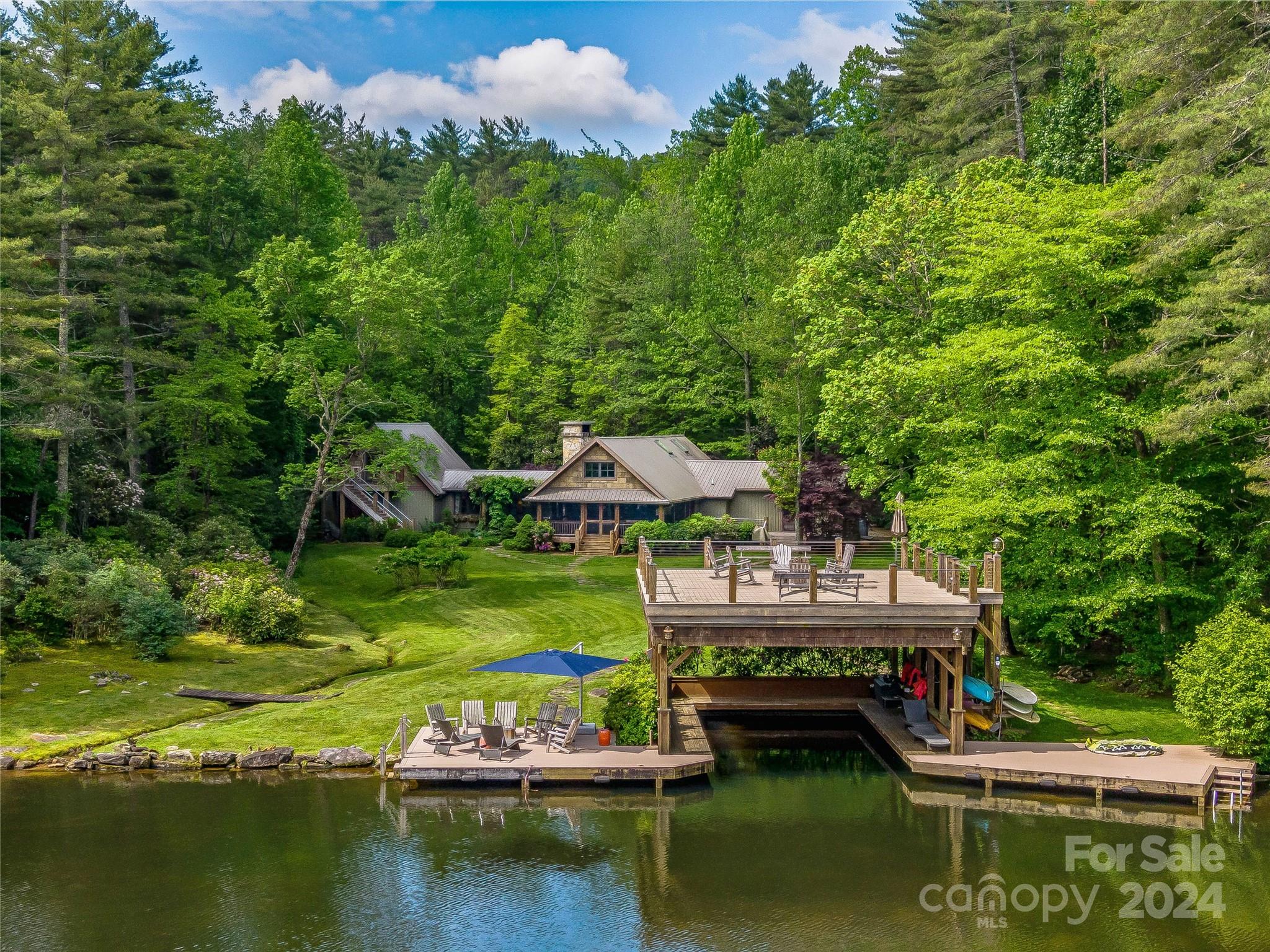 Welcome to your dream lakefront retreat, a stunning home with a guest suite situated on a combined double lot. This property offers 4 beds, 4.5 baths providing ample space for family and guests to enjoy life on the lake.Step outside to the stone path leading to the double bay boathouse and dock, complete with swim steps for easy water access.Once inside the home, the open-concept kitchen, dining, and living areas are adorned with antique beams and skylights, creating a bright and rustic atmosphere.Heart pine floors add warmth and timeless elegance throughout the home. The primary suite offers direct access to the expansive deck.Rinse off after a day in the lake in the outdoor shower, or relax in the screened porch. The separate guest suite has 278 of additional square footage. This residence’s private, park-like setting, luxurious features, and outdoor spaces creates the perfect opportunity for those who value both comfort and nature.