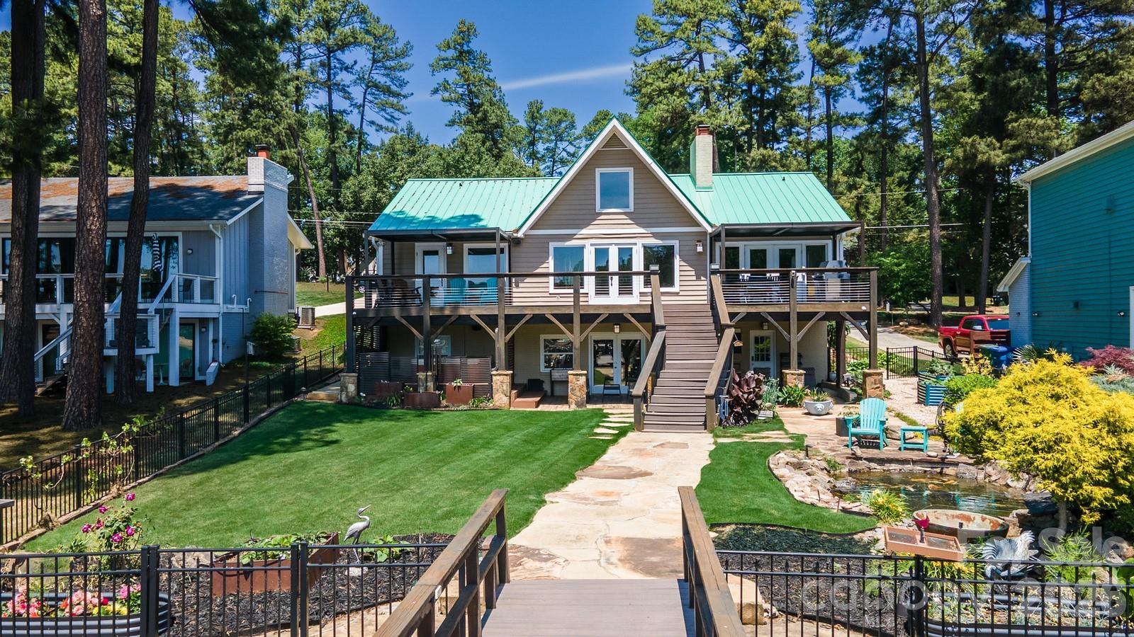 Premier waterfront home with majestic main channel views of Lake Norman!  Surrounded by water, this home is situated in the highly desirable Island Forest neighborhood; facing southwest allows for magnificent sunsets! The aerial photos tell it all!  Spacious, open floor plan. Beautiful bamboo hardwood floors in dining room, great room and loft. Awesome kitchen complete with granite/wood countertops, breakfast bar, tile backsplash, gourmet gas stove, vented hood and plenty of cabinet space. Large, open great room features vaulted ceiling, gas masonry fireplace and wonderful natural light. Wake up to lake views from the large, main level primary bedroom. Upper-level loft is perfect for a reading area or playroom. Large entertaining area on lake level offers ample space for pool table, wet bar area, plenty of living space and 2nd masonry fireplace with gas logs.  Absorb breathtaking views from the upper deck or covered lake level patio. Hot tub located directly off the large covered back porch offers wonderful opportunities to unwind anytime.  Striking metal roof adds to the lake-house feel. Beautifully landscaped yard features zoysia grass, mature palm trees, stone walkways, fully fenced backyard, fully functional Koa Pond. Expansive pier includes covered sitting area and 10,000lb boatlift. Tankless water heater, Generac generator, "lake water" in-ground irrigation.  Island Forest neighborhood offers private/gated (residence only) waterfront lot complete with boat ramp and pier! Prime location near parks, restaurants, and boutique shopping.   This residence defines the vibrant Lake Norman way of life! Experience the ultimate Lake Norman lifestyle!