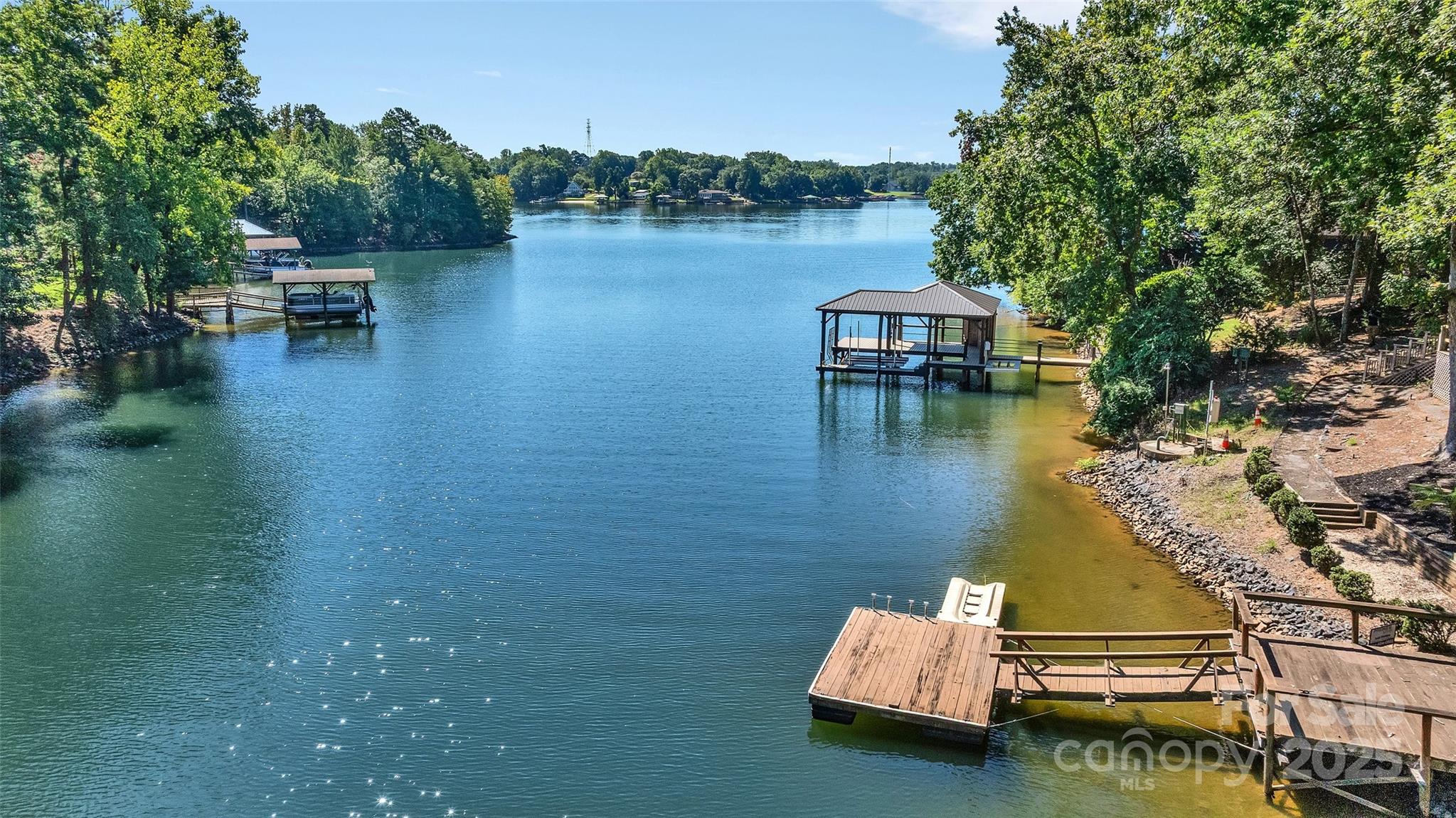 Waterfront on Lake Wylie in Tega Cay, SC!  Double LOT, flat .42 Acre, approx 112 ft of lakefront! Cul de Sac street. Two car Detached GARAGE is 585 sq ft! Long Concrete Driveway 2023, LOTS of parking & the ability to pull in circle around to drive out behind the garage. Trek deck across the back of the house with cable railing 2023. Slope to water with stationary & floating dock. Large Primary Bedroom on Main level with Sunroom. Kitchen has gray cabinetry, quartz countertops with stainless appliances, & gas range. Bar in Dining Area. Lower level has 3 Bedrooms with brand new carpet plus Bonus room & wet bar.  Screen porch off Bedroom 2 with a lake view. Covered deck & multi levels with seating areas to enjoy the Lake Wylie water views. Fenced backyard with greenhouse.  Fort Mill Schools, please verify for current assignments. Tega Cay is a waterfront, recreational city on the shores of Lake Wylie in South Carolina.  Enjoy the Tega Cay Golf Club, waterfront parks, beaches, trails, pickleball, tennis, sports, playgrounds, Tega Cay Beach & Swim Club & more! NO HOA.  NOW Offering $10,000 credit with acceptable offer.