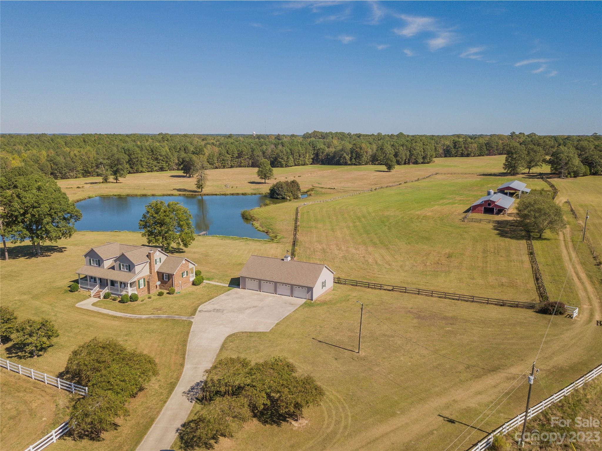 Come see this piece of paradise. The beautiful house is tucked away from the road with the Master Bedroom on the main level and a gorgeous sunroom overlooking the pasture. Property includes two large barns and extra deep four-bay garage with work bench and cabinets. Pasture is all cleared and cut and entirely fenced. White vinyl fence up front with wire mesh horse fence on remaining sides. Multiple gates throughout to isolate one pasture from another. Three water stations included. There is also a cattle shoot and holding pen. You'll find a diesel fueling station at one barn. There are also two hay rings and a water trough. One barn with hay loft and stalls. The other is open on three sides. Two stocked ponds approximately three to four acres each. This property is absolutely gorgeous. Scenic views everywhere you look. Schedule a tour today!