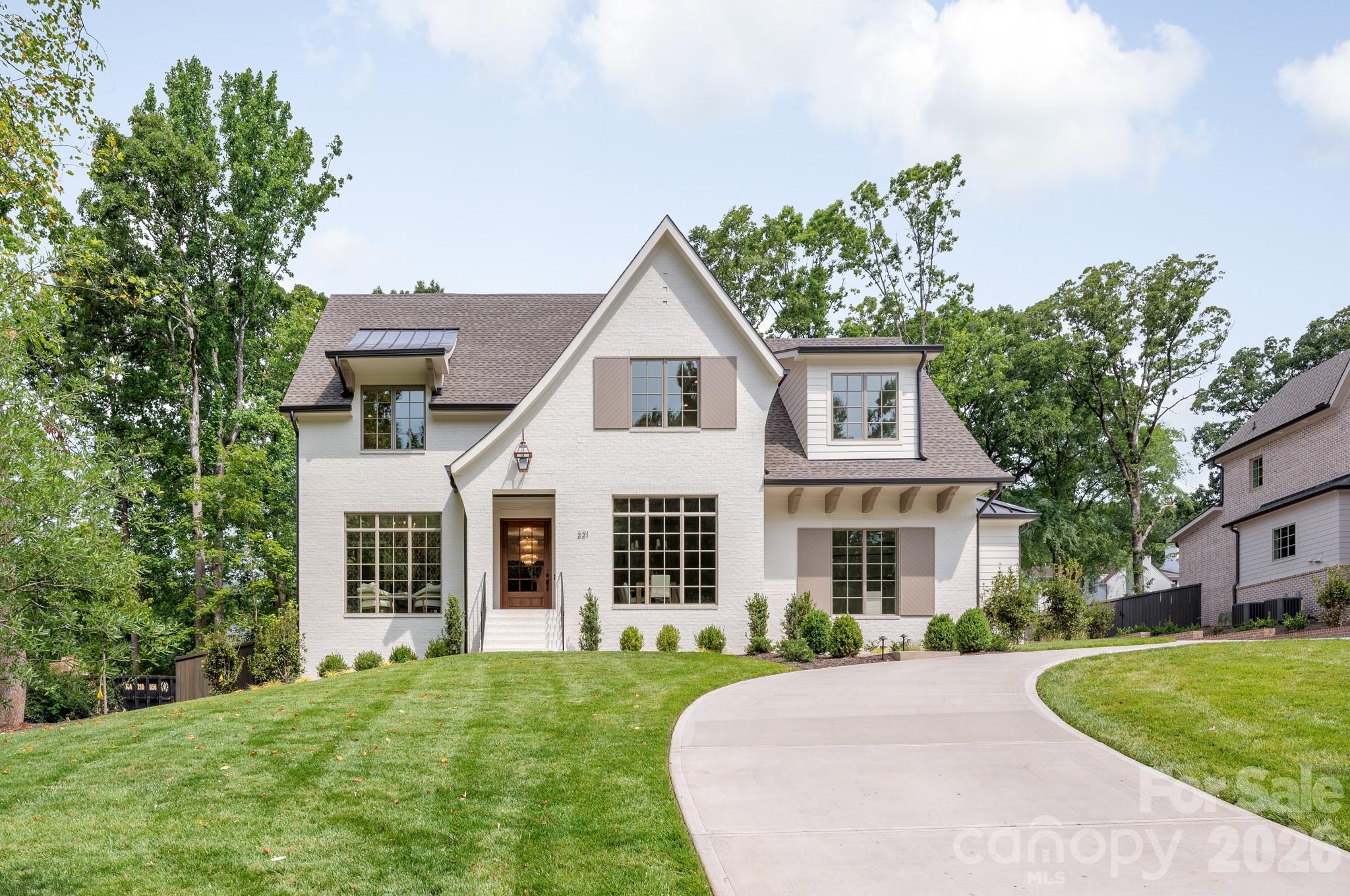 Exceptional new construction in the heart of Cotswold, offering over 5,000 sf of thoughtfully designed spaces, 10' ceilings and a beautiful half-acre lot.  Primary suite on main is a true retreat featuring a spa bath and 2nd laundry within the expansive walk-in closet. Chef's kitchen has a large island with built-in banquette seating and opens to living room with fireplace and built-ins.  Stunning dining room is accented by stained wood ceiling details. A spacious scullery/butler's pantry provides beautiful and functional storage with a second dishwasher and refrigerator, microwave and wine cooler. The covered porch offers perfect space for indoor/outdoor living and includes a fireplace, retractable screens, and ceiling heaters. Overlooking a private backyard with ample room for a pool and mature trees for shade and character, gorgeous landscaping and exterior lighting. Upstairs, four additional bedrooms and a large bonus room provide plenty of spaces for family and guests. Additional highlights include beautiful white oak hardwood floors, an architecturally striking front entry, and a well designed mudroom with a built-in desk - perfect space for keeping the home organized. Ready for move in and located near Charlotte's private school corridor with an easy commute to Uptown, SouthPark, great dining and shopping options.